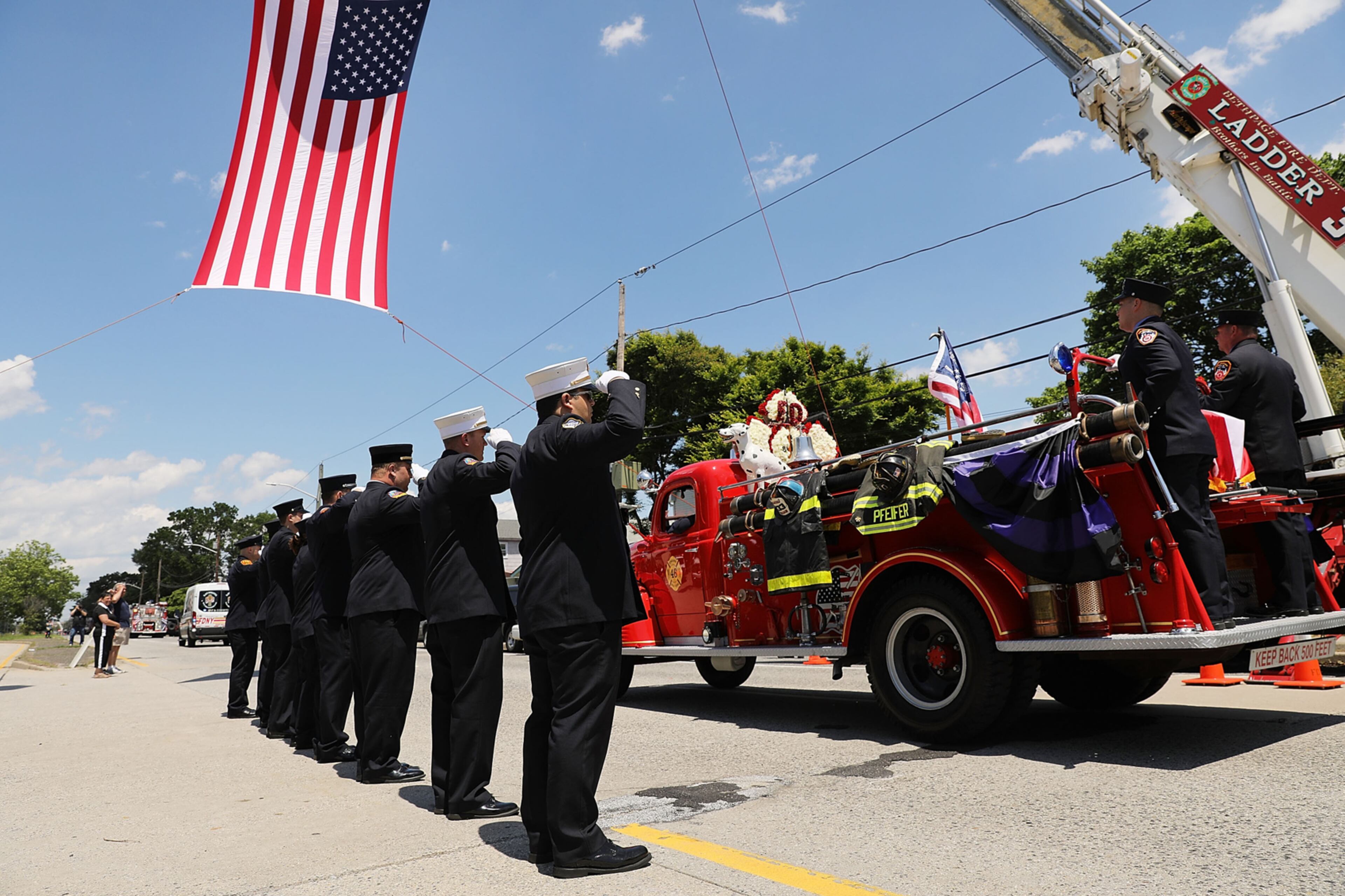 HICKSVILLE, NY - JUNE 02: The casket of retired FDNY firefighter Ray Pfeifer drives away from a church on an antique fire truck on June 2, 2017 in Hicksville, New York. Pfeifer, 59, fought a years-long battle with cancer attributed to his work at Ground Zero after the 9/11 terrorist attacks. The 27-year FDNY veteran spent about eight months working on the pile site of debris in lower Manhattan and was instrumental in getting lawmakers to pass the James L. Zadroga 9/11 Health & Compensation Act. (Photo by Spencer Platt/Getty Images)