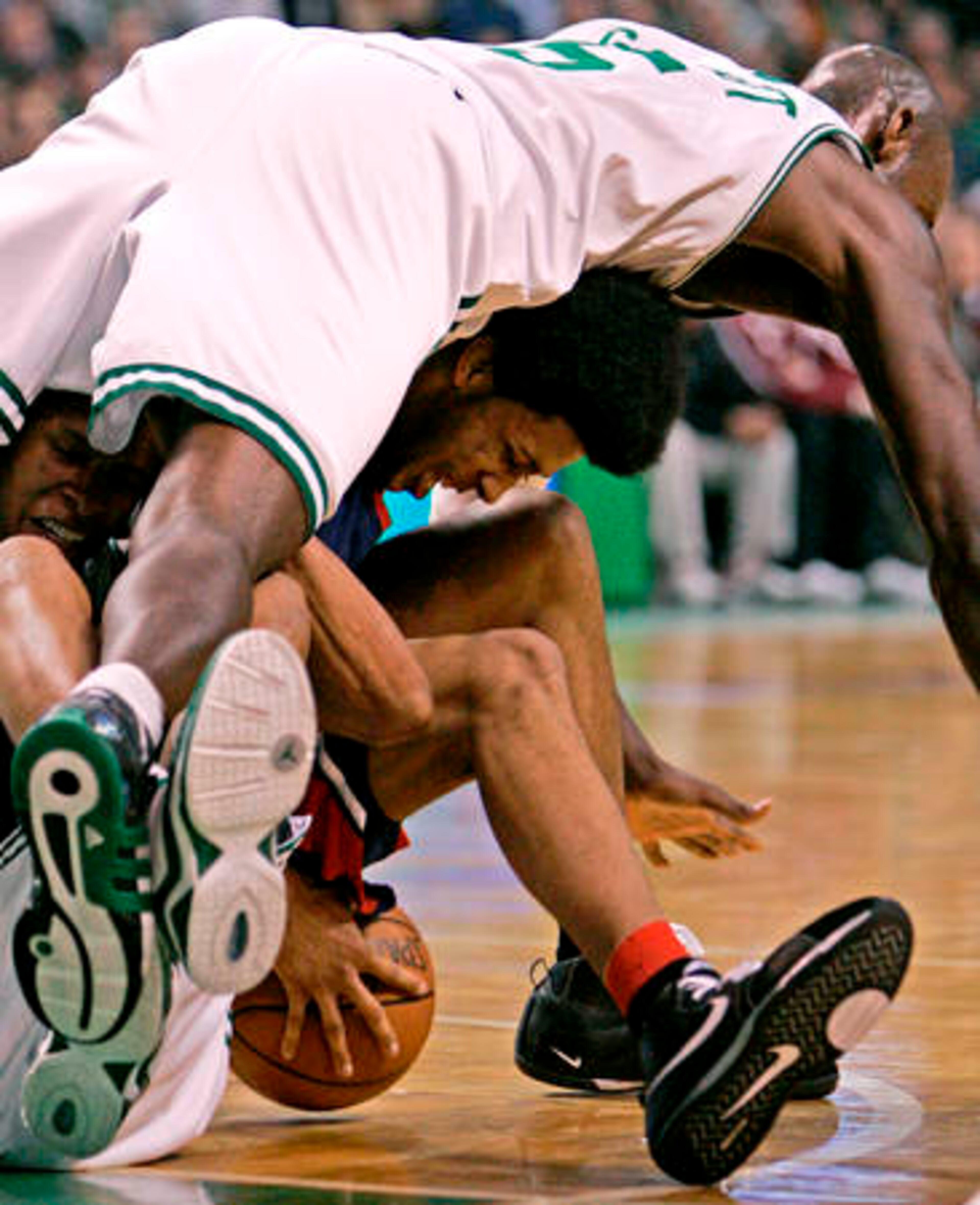 Boston Celtics forward Kevin Garnett (top) lands on Atlanta Hawks guard Josh Childress as they battle for a loose ball in game one of their NBA first-round playoff series in Boston on Sunday. The Celtics won, 114-81.