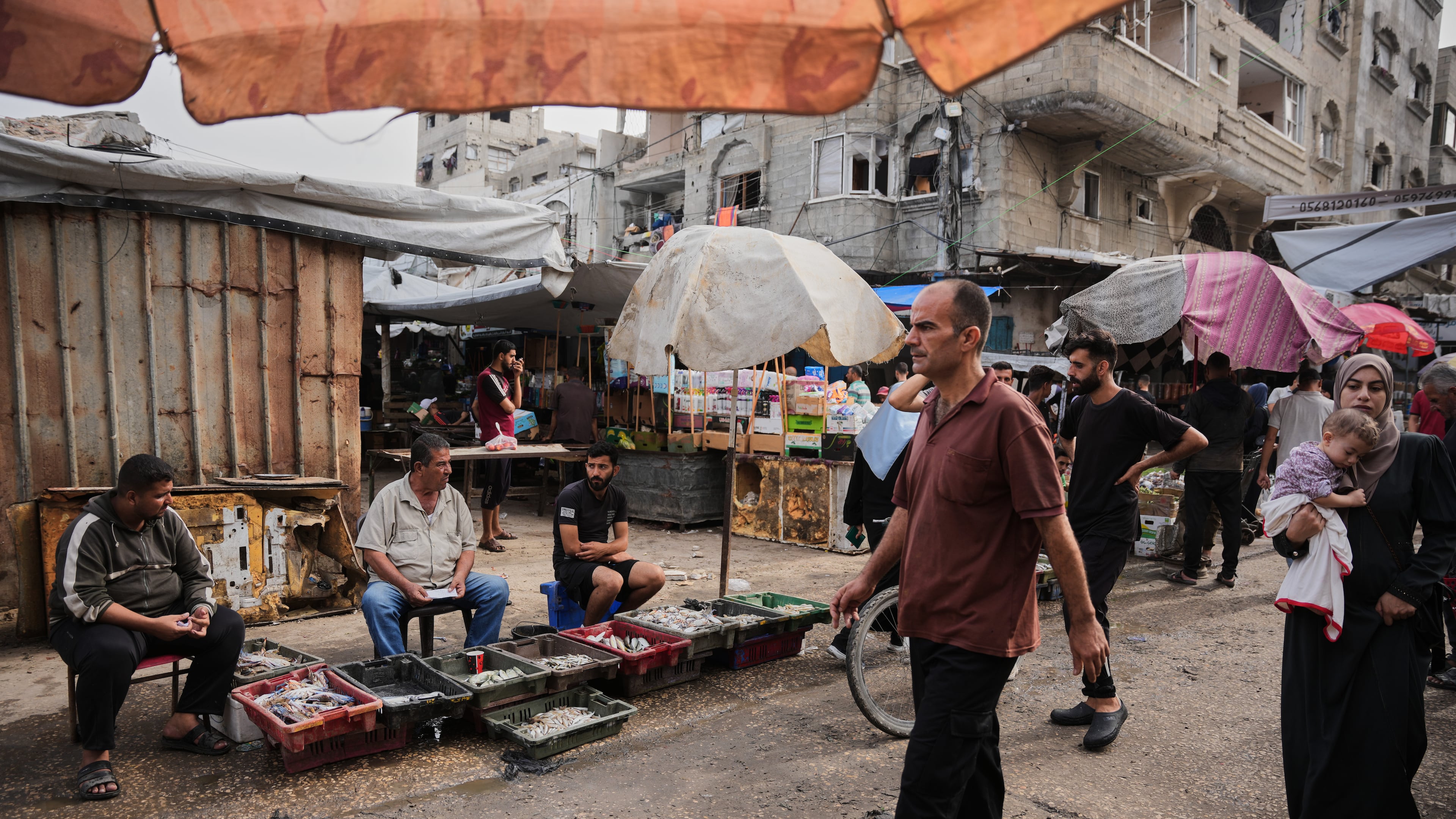 Palestinians walk through a market in the Al-Shati refugee camp in Gaza City on Wednesday, Oct. 14, 2026. (AP Photo/Abdel Kareem Hana)