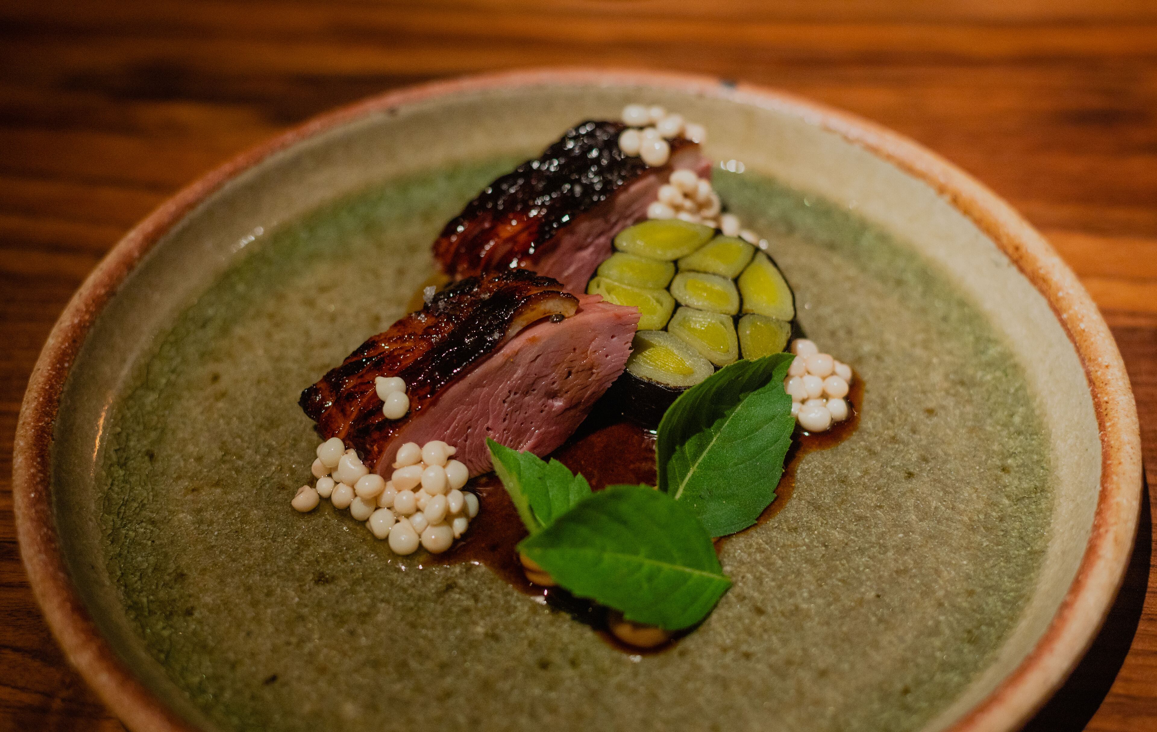 Duck with leeks and Holy Basil, topped with crisp okra seeds, at Uberto. (Credit: Henri Hollis / henri.hollis@ajc.com)