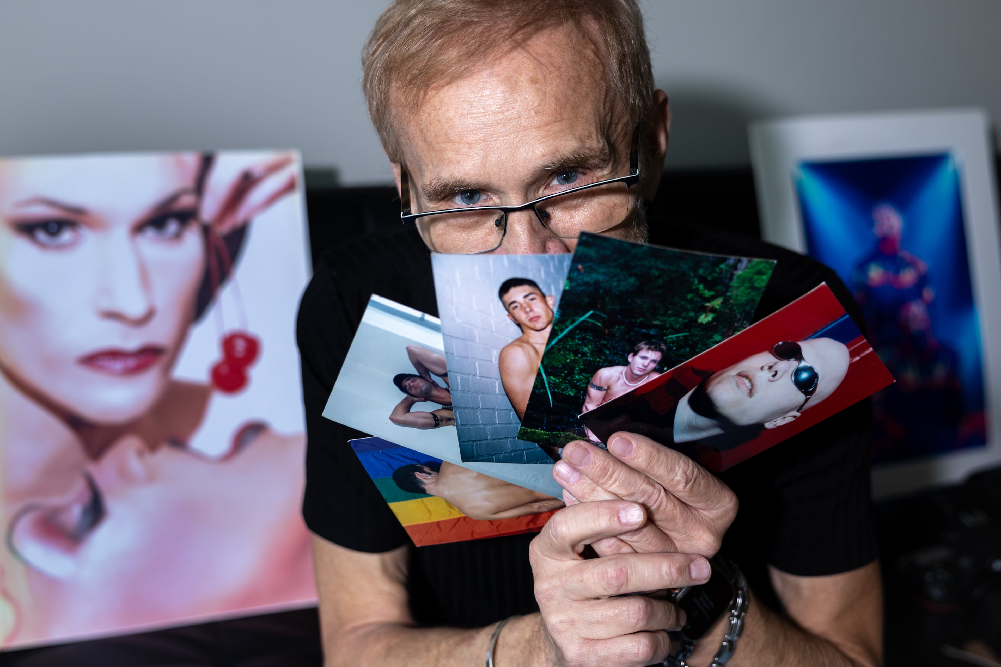 Photographer Russ Youngblood, who has documented the gay community for decades, poses for a portrait with some of his photos at his home in Atlanta on Oct. 8, 2026. (Arvin Temkar/AJC)