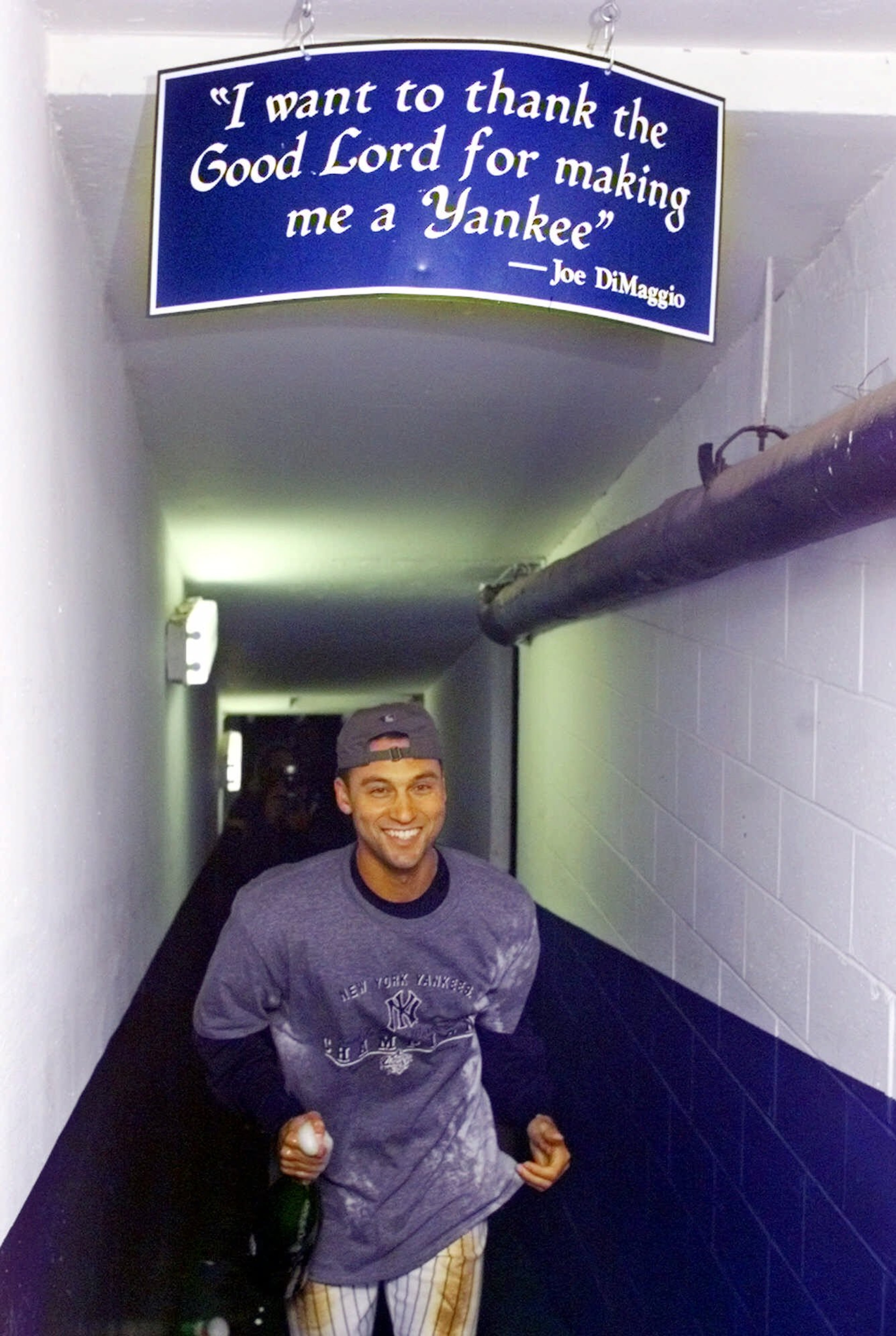 FILE - In this Oct. 27, 1999, file photo, New York Yankees shortstop Derek Jeter runs toward the Clubhouse under a sign quoting Yankee legend Joe DiMaggio after his team swept the Atlanta Braves in the World Series in New York. Jeter is set to retire after this weekend. A five-time World Series champion and sixth on the career hits list, he spent two decades as the shortstop for the New York Yankees. (AP Photo/Mark Lennihan)