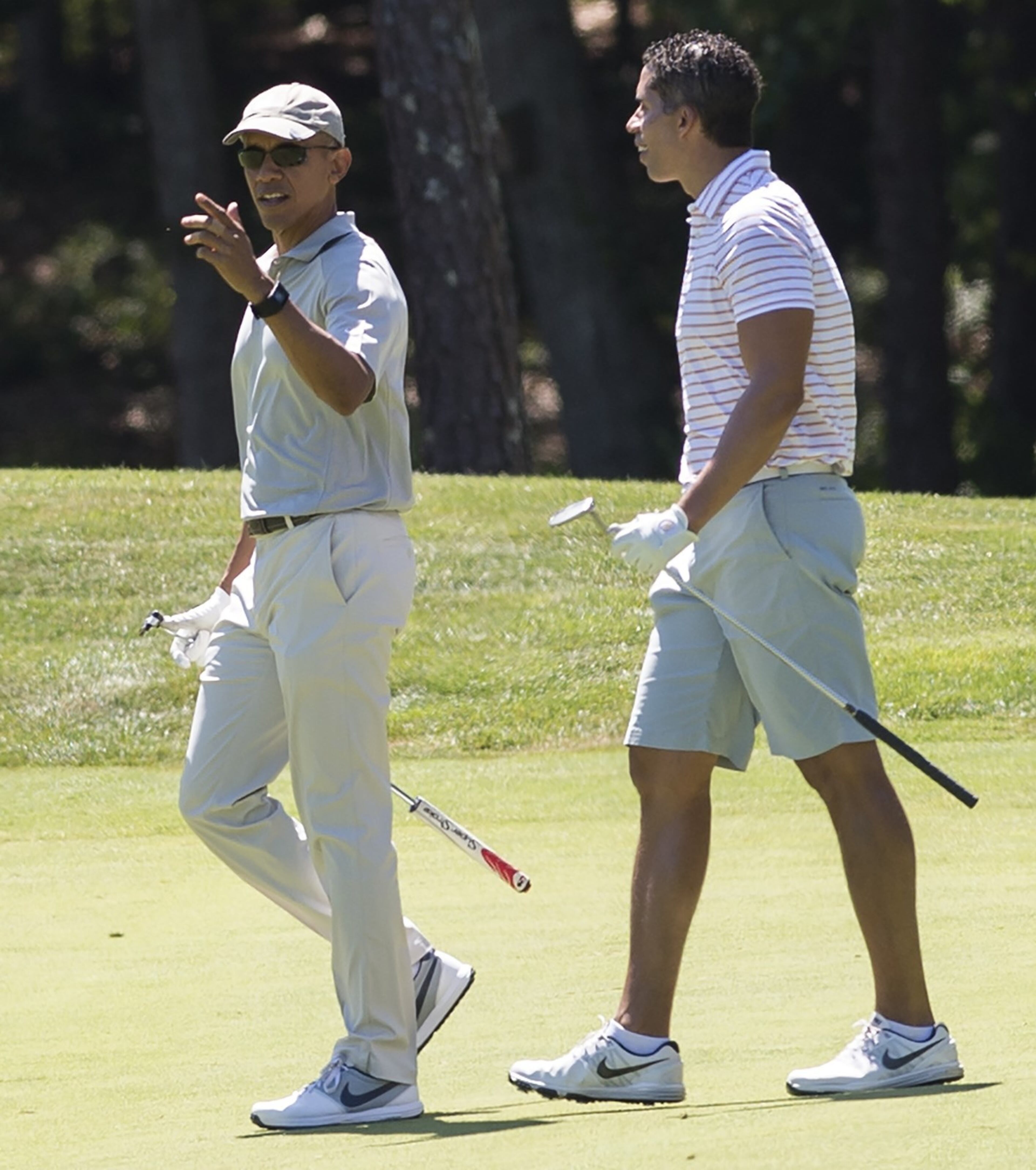 US President Barack Obama walks alongside Cyrus Walker (R) as they play golf at Farm Neck Golf Club in Oak Bluffs on Martha's Vineyard in Massachusetts, August 8, 2015. The Obama family is on a 2-week vacation. AFP PHOTO / SAUL LOEB (Photo credit should read SAUL LOEB/AFP/Getty Images)