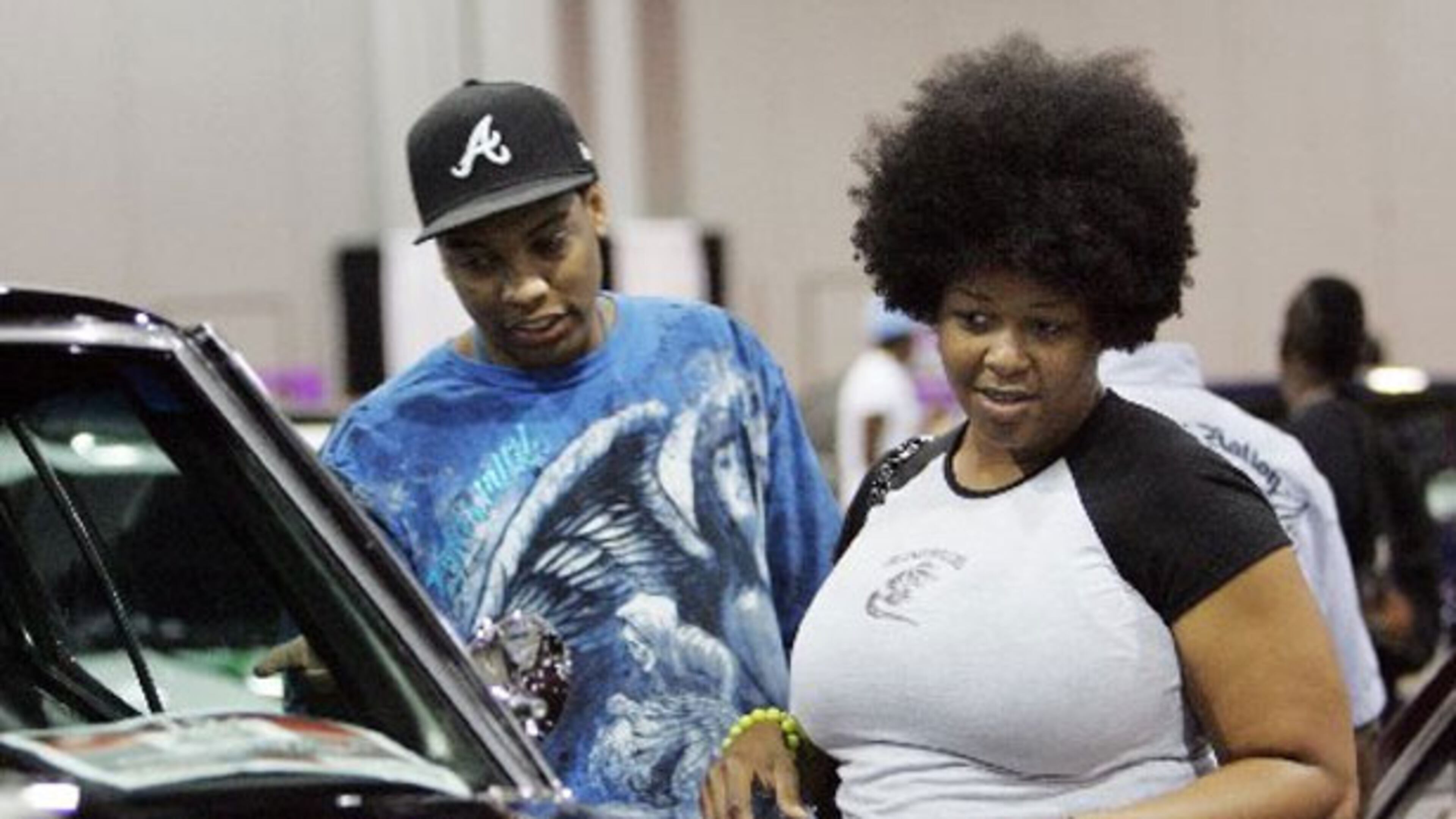 Jamal Evans & Trieva Brown check out a custom car at the V-103 Car and Bike show at the Georgia World Congress Center.