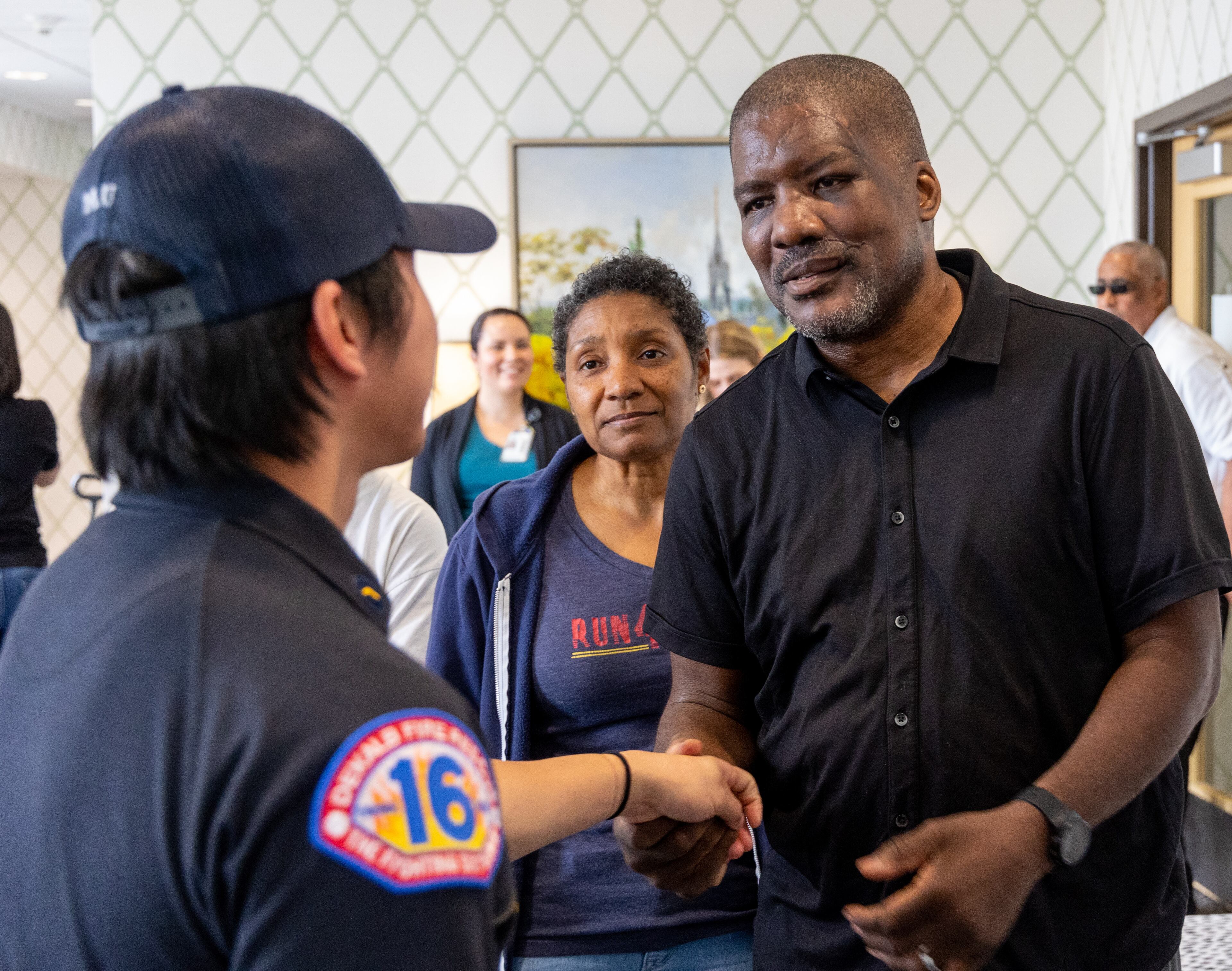 (right to left) Fulton County Fire Department Lieutenant Mark Quick and his wife Anita thank DeKalb County Fire Rescue member Nishan Mu (back to camera) who helped save Lt. Quick's life.
PHIL SKINNER FOR THE ATLANTA JOURNAL-CONSTITUTION