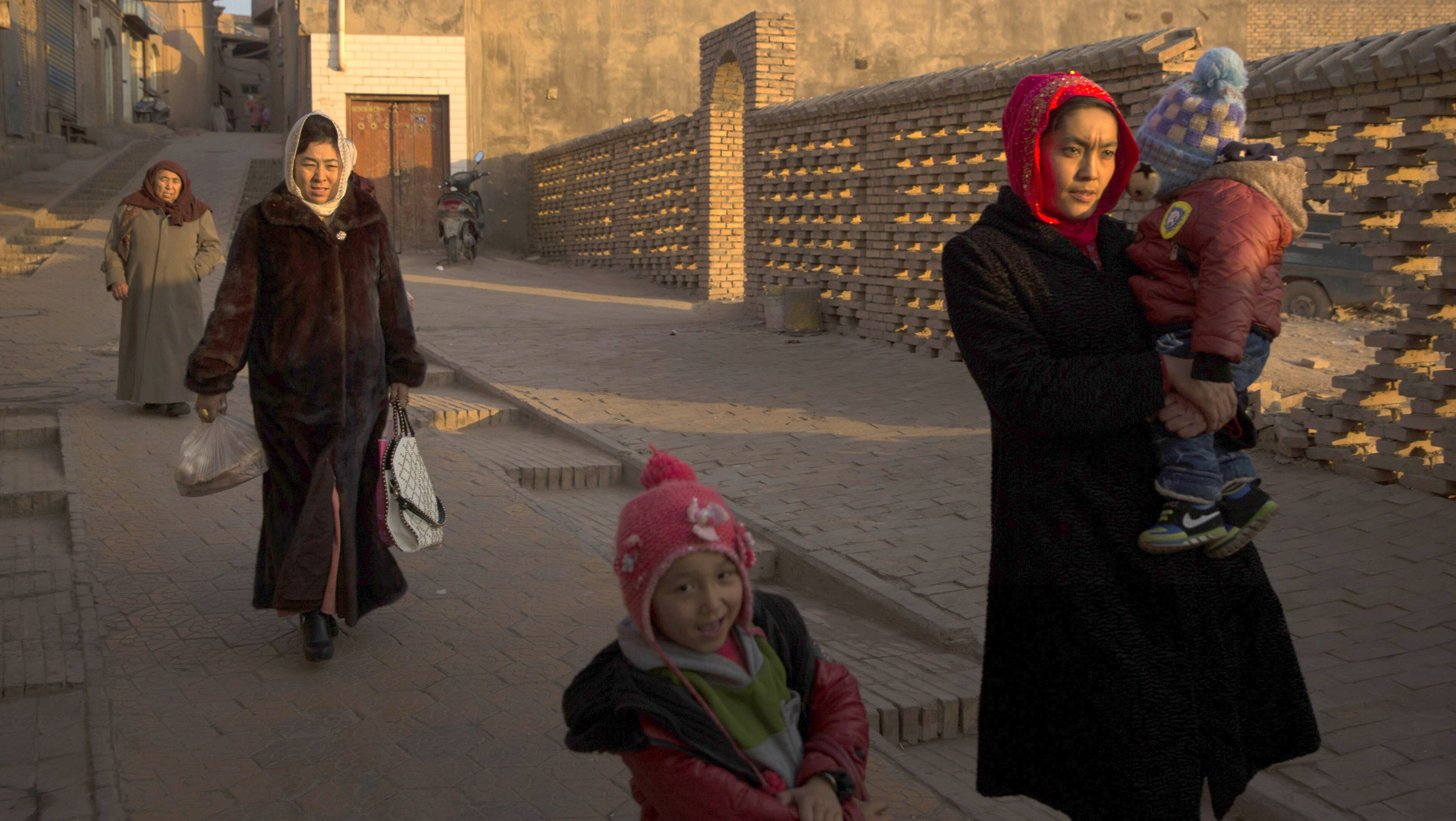 Uighur women walk through the old city of Kashgar, in China’s far western province of Xinjiang. Ostensibly in response to the threat of Muslim extremists, Chinese authorities have imposed tough new measures here that have left many in Xinjiang seething with anger. (Adam Dean/The New York Times)