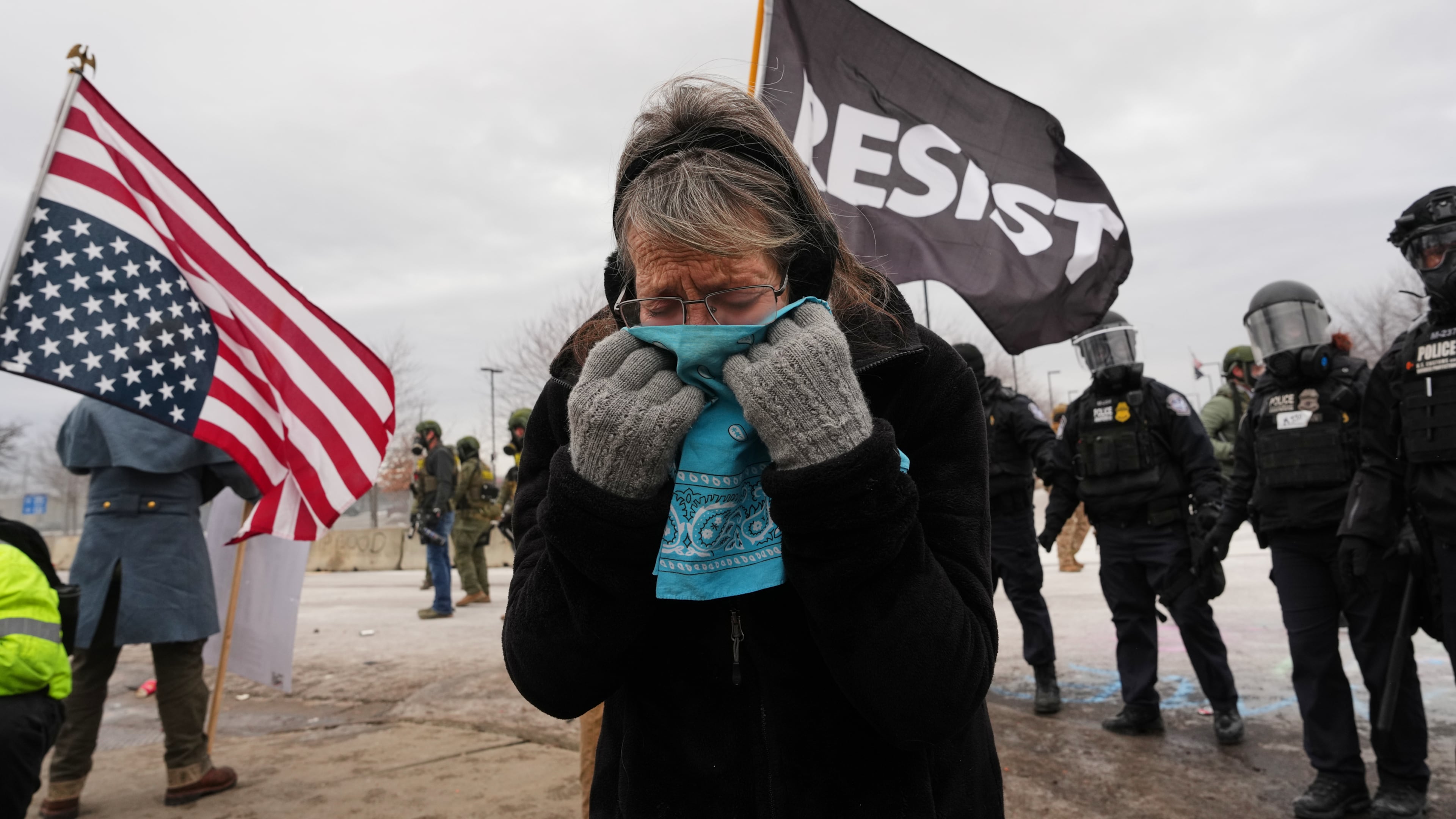 A woman covers her face from tear gas as federal immigration officers confront protesters outside Bishop Henry Whipple Federal Building, Thursday, Jan. 15, 2026, in Minneapolis. (AP Photo/Adam Gray)