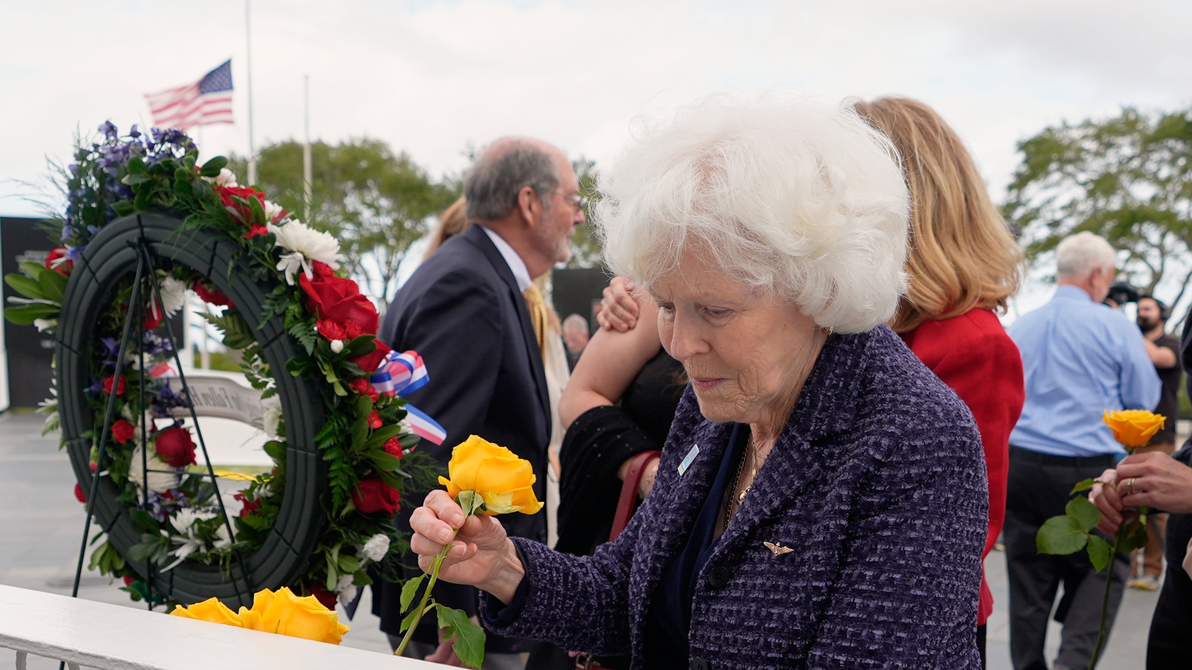 Jane Smith-Wolcott, center, widow of Challenger pilot Michael Smith puts a flower on a memorial during NASA's Day of Remembrance for the 40th Anniversary of the Challenger tragedy at the Kennedy Space Center Visitor Complex in Cape Canaveral, Fla., Thursday, Jan. 22, 2026. (AP Photo/John Raoux)