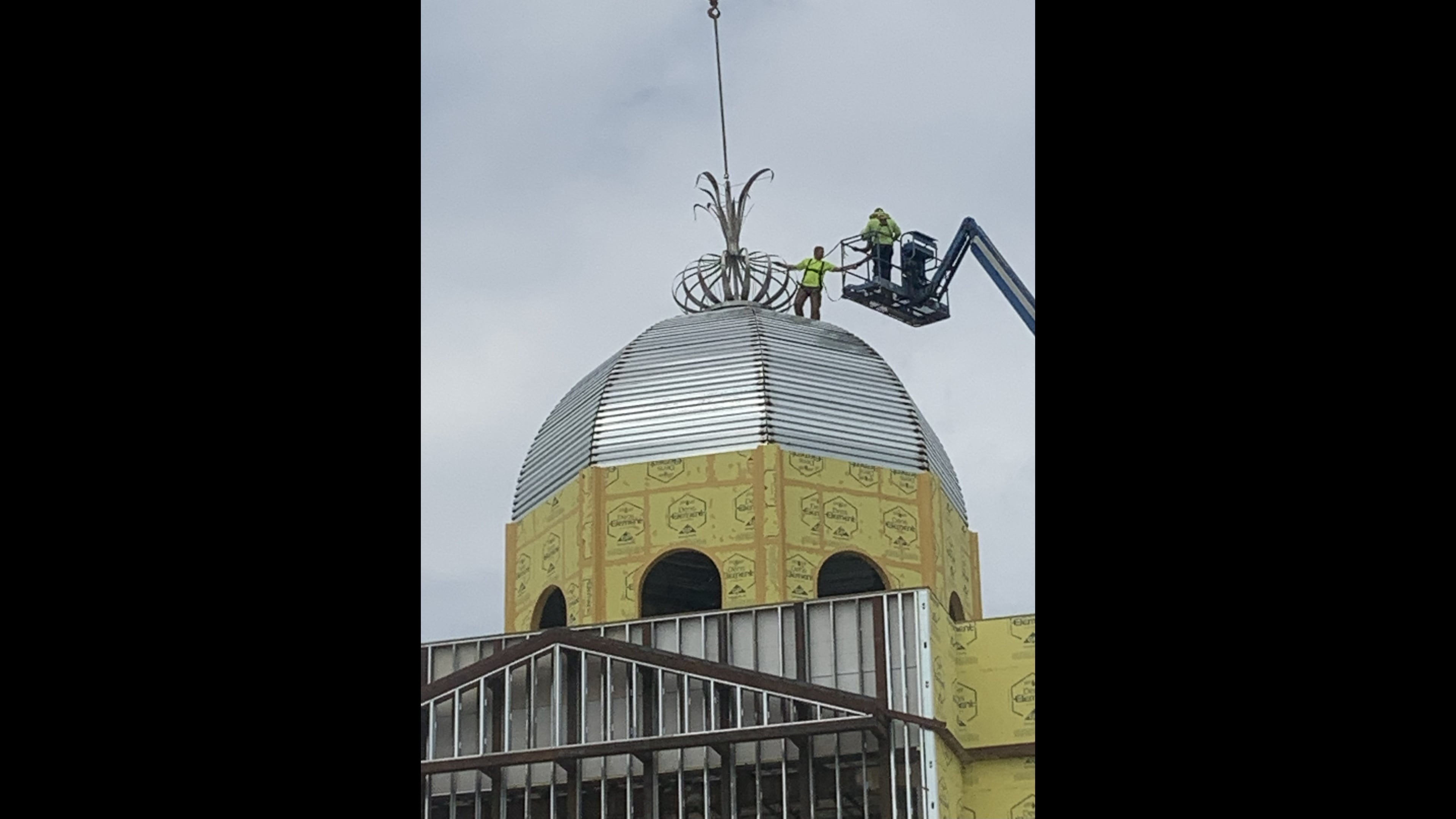 Workers install the stainless steel onion sculpture on the roof of Toombs County's courthouse in 2023. (Courtesy of John Jones)
