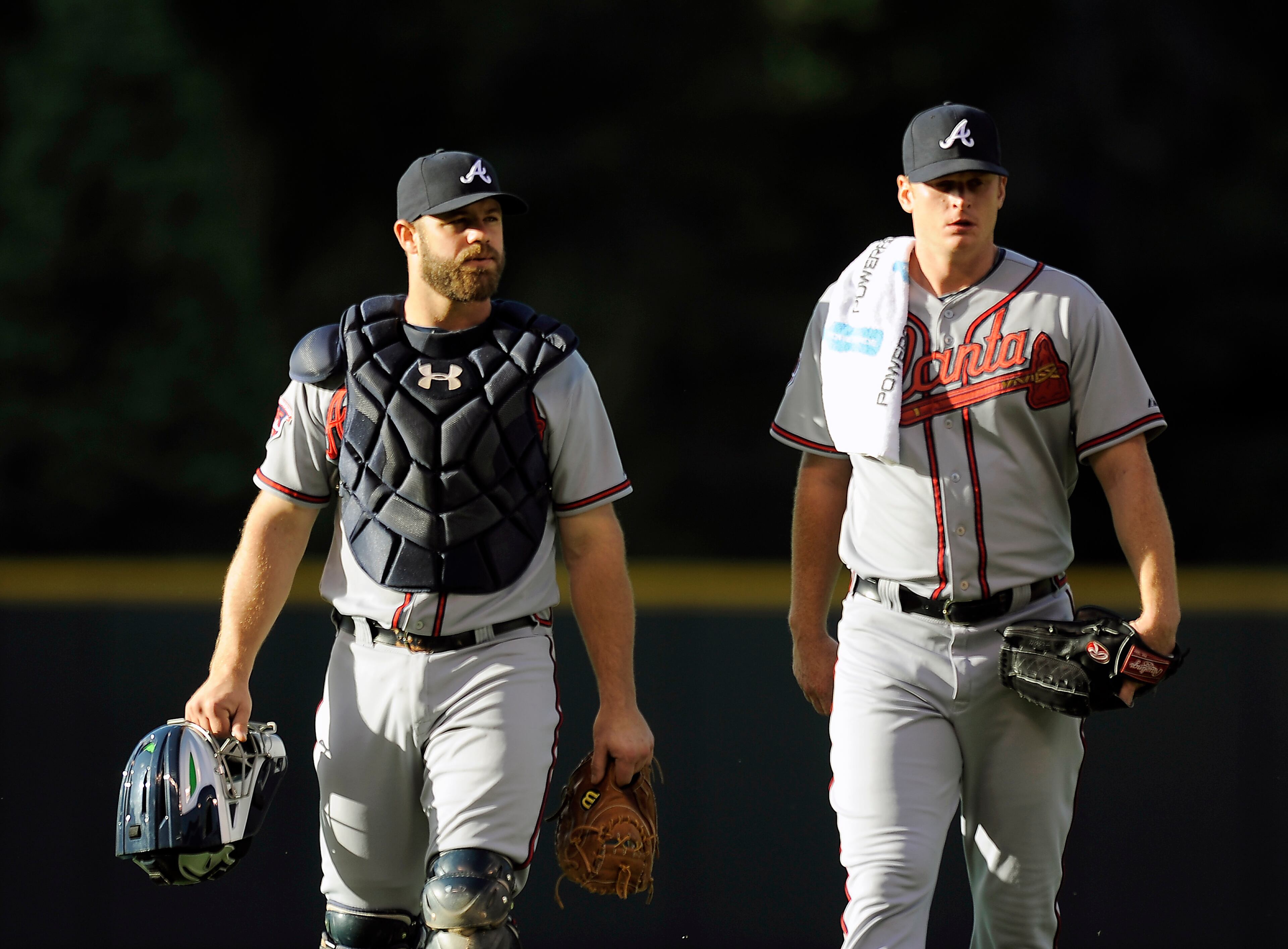 Atlanta Braves catcher Evan Gattis, left, and starting pitcher Gavin Floyd, right, walk to the dugout before the start of a baseball game against the Colorado Rockies on Monday, June 9, 2014, in Denver. (AP Photo/Chris Schneider)