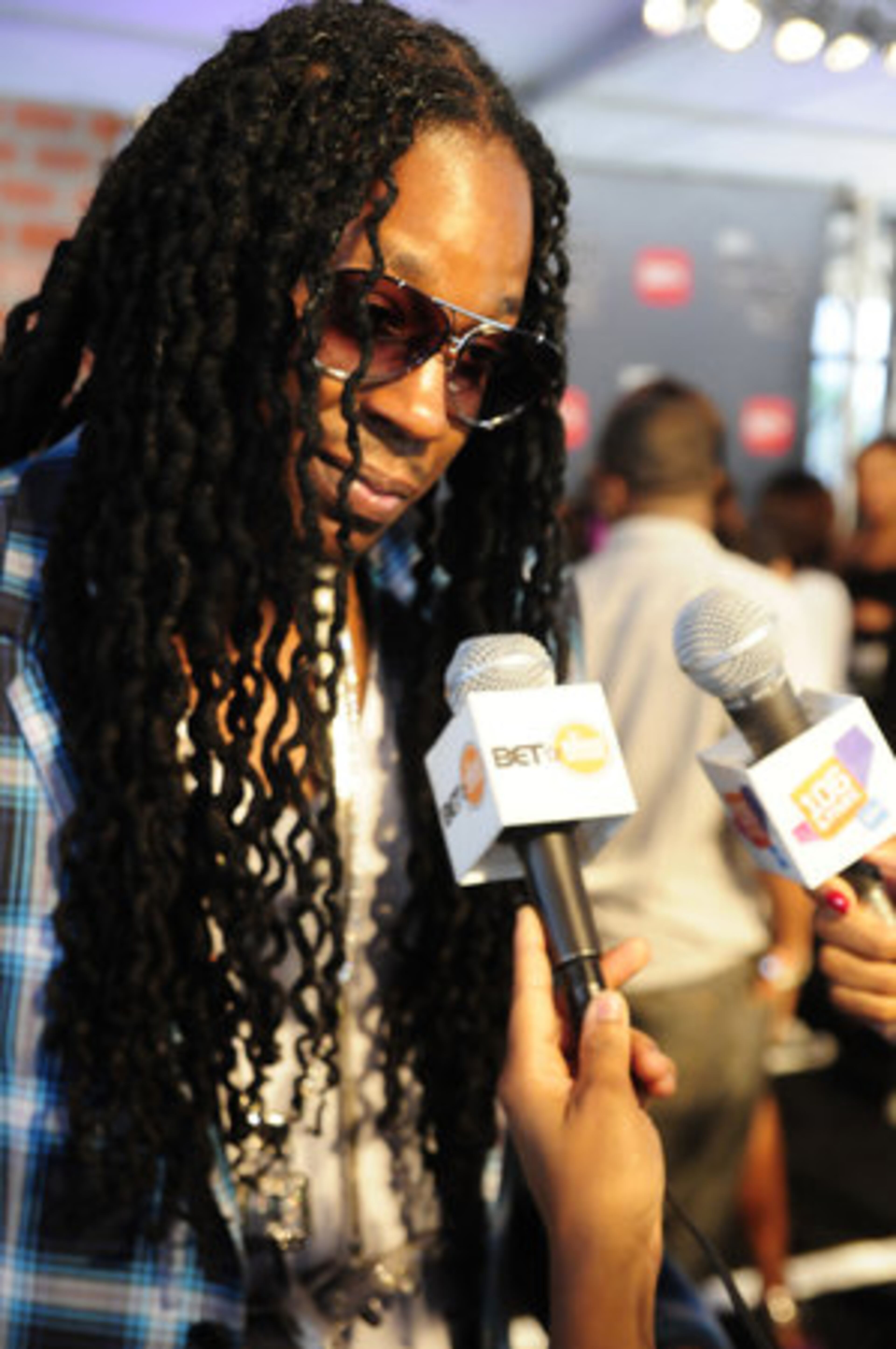 2Chainz lets his hair down to talk with reporters.