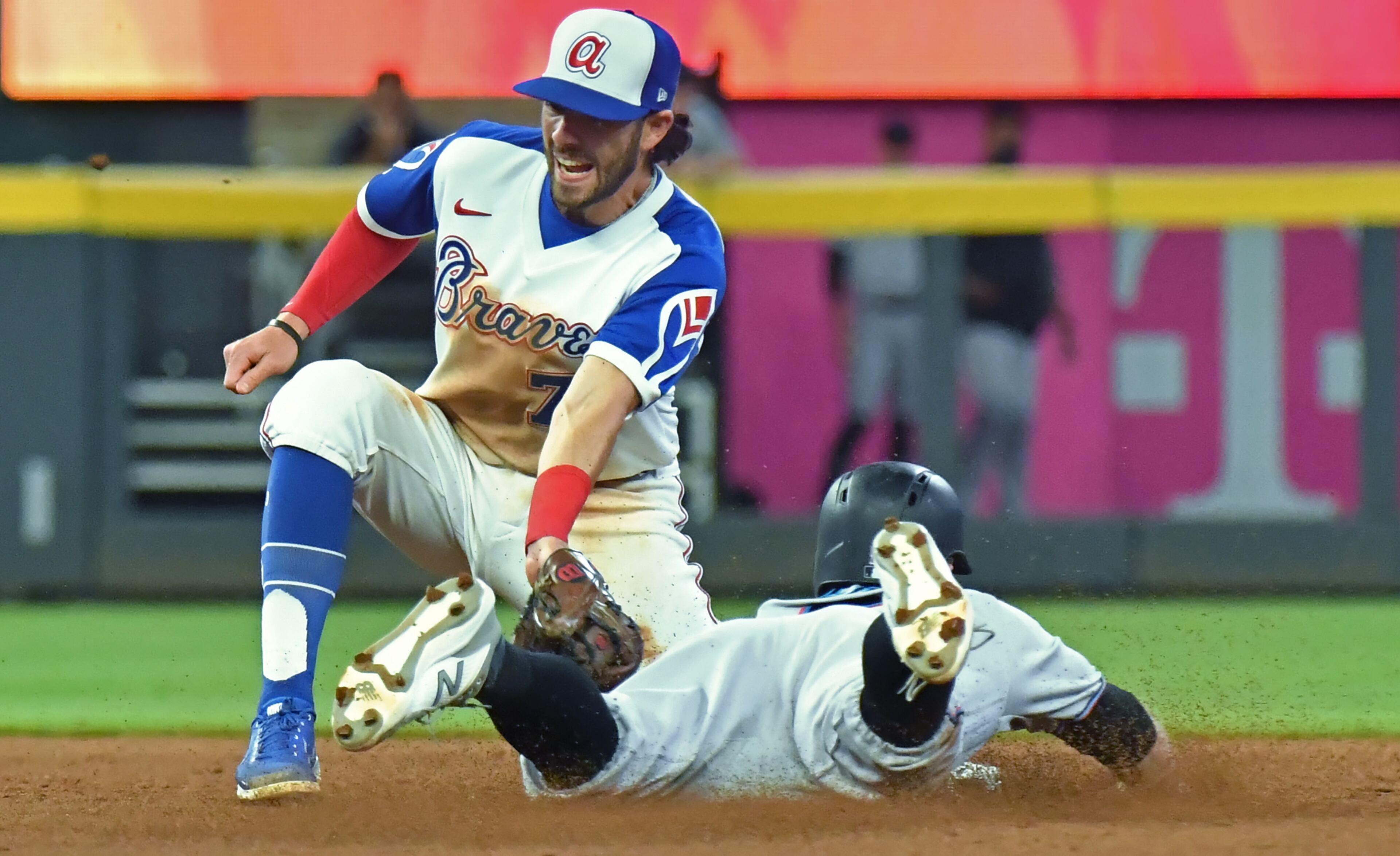 April 12, 2021 Atlanta - Miami Marlins third baseman Jon Berti (5) slides into second base as Atlanta Braves shortstop Dansby Swanson (7) applies a tag in the 8th inning at Truist Park on Monday, April 12, 2021. Atlanta Braves challenged the call and it overturned. Atlanta Braves Miami Marlins won 5-3 over Atlanta Braves in an extra inning. (Hyosub Shin / Hyosub.Shin@ajc.com)