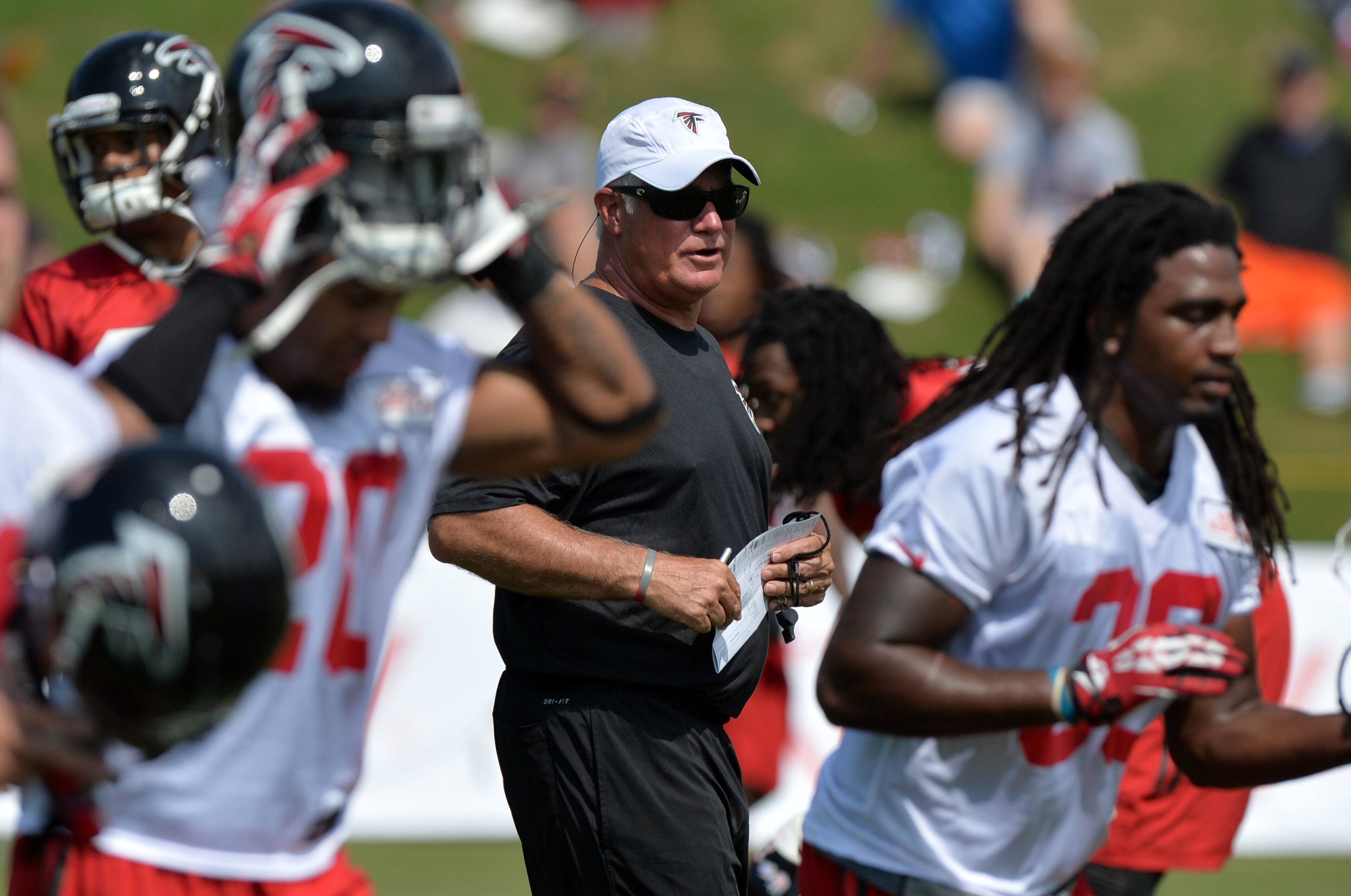 Atlanta Falcons head coach Mike Smith walks the field during training camp on Friday, July 25, 2014.