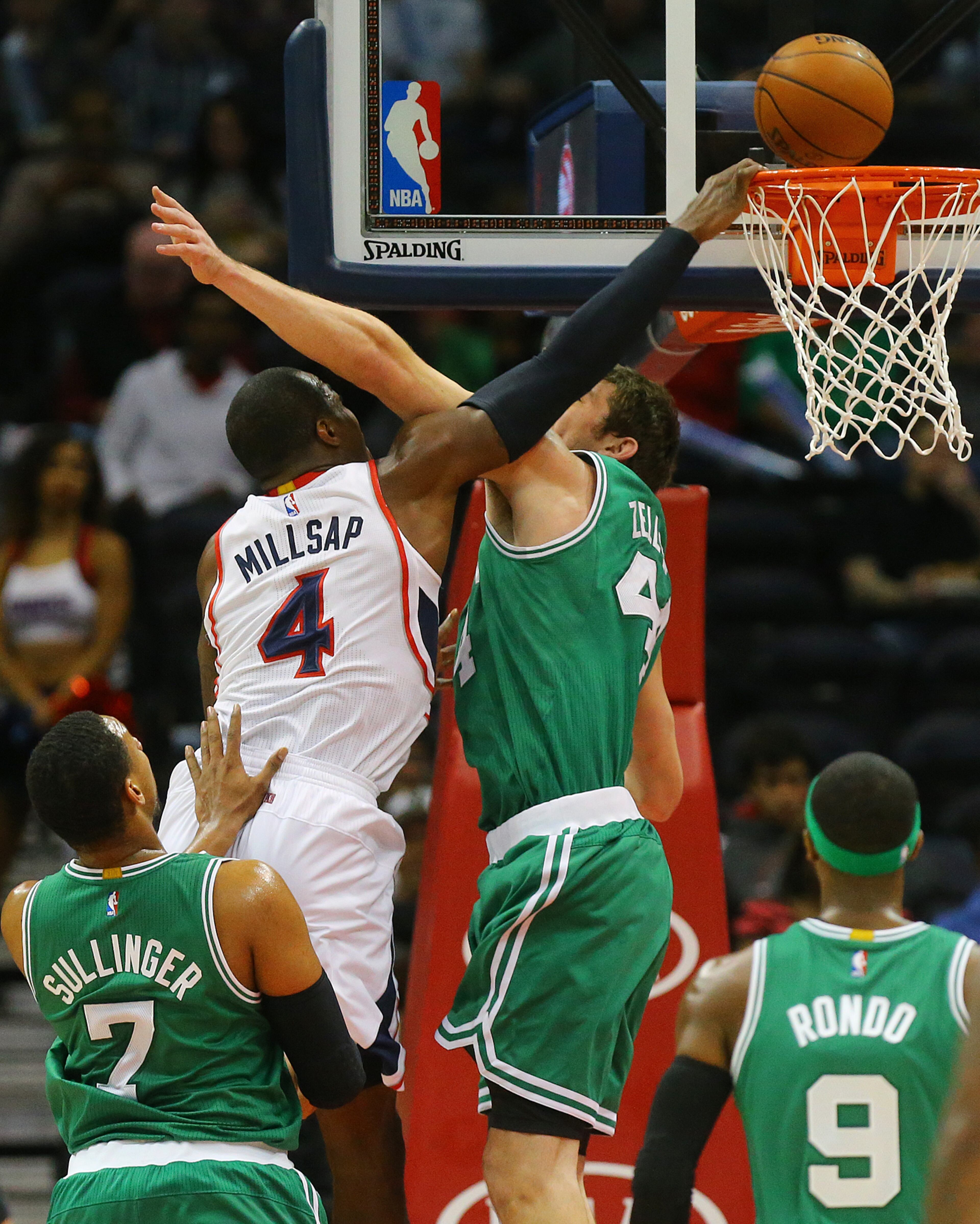 Celtics Tyler Zeller defends against Hawks Paul Millsap who can't get the dunk bouncing off the rim during the first half in an NBA basketball game on Tuesday, Dec. 2, 2014, in Atlanta. CURTIS COMPTON / CCOMPTON@AJC.COM