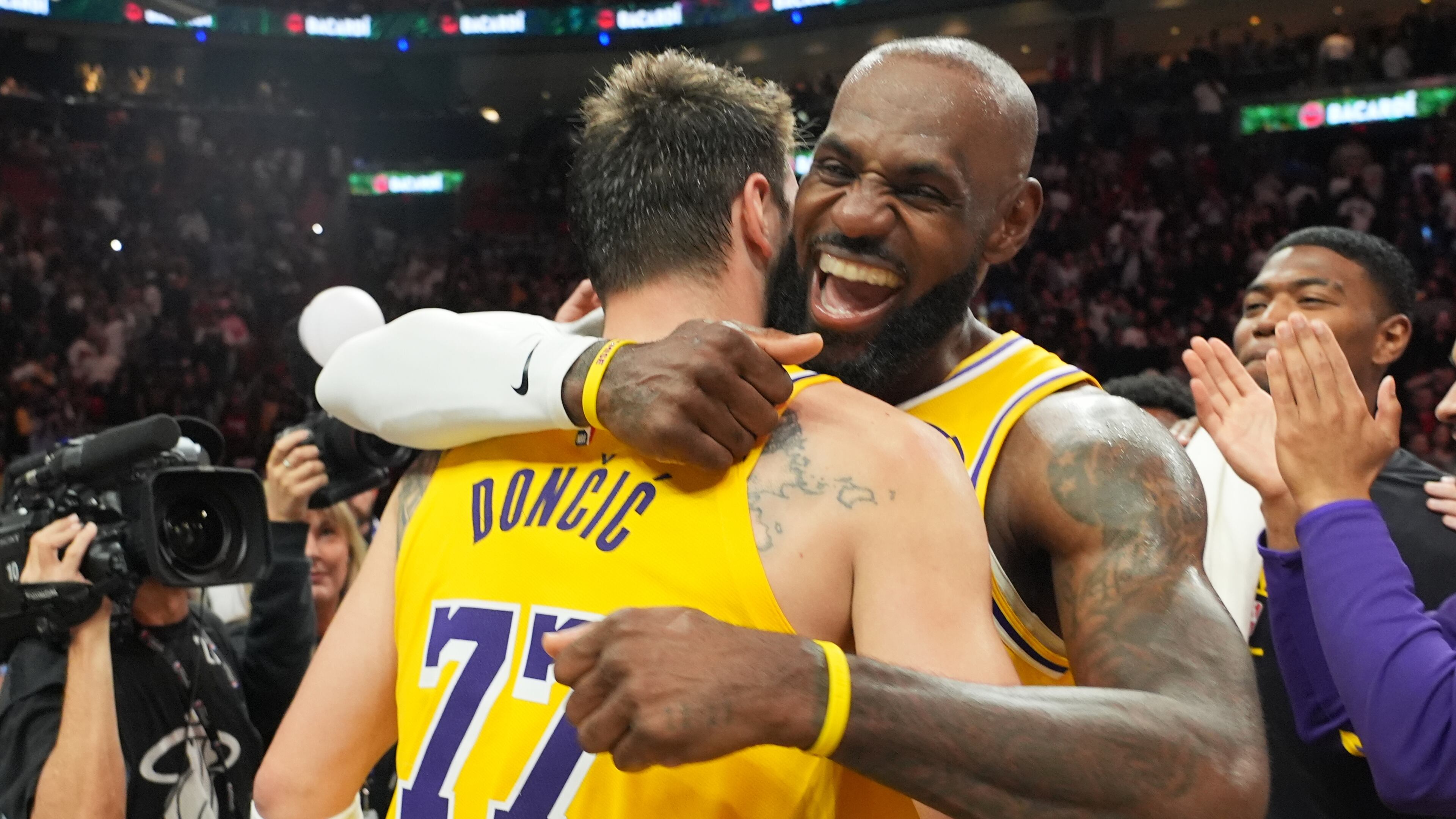 Los Angeles Lakers guard Luka Doncic (77) and forward LeBron James, right, embrace after defeating the Miami Heat in an NBA basketball game, Thursday, March 19, 2026, in Miami. (AP Photo/Lynne Sladky)