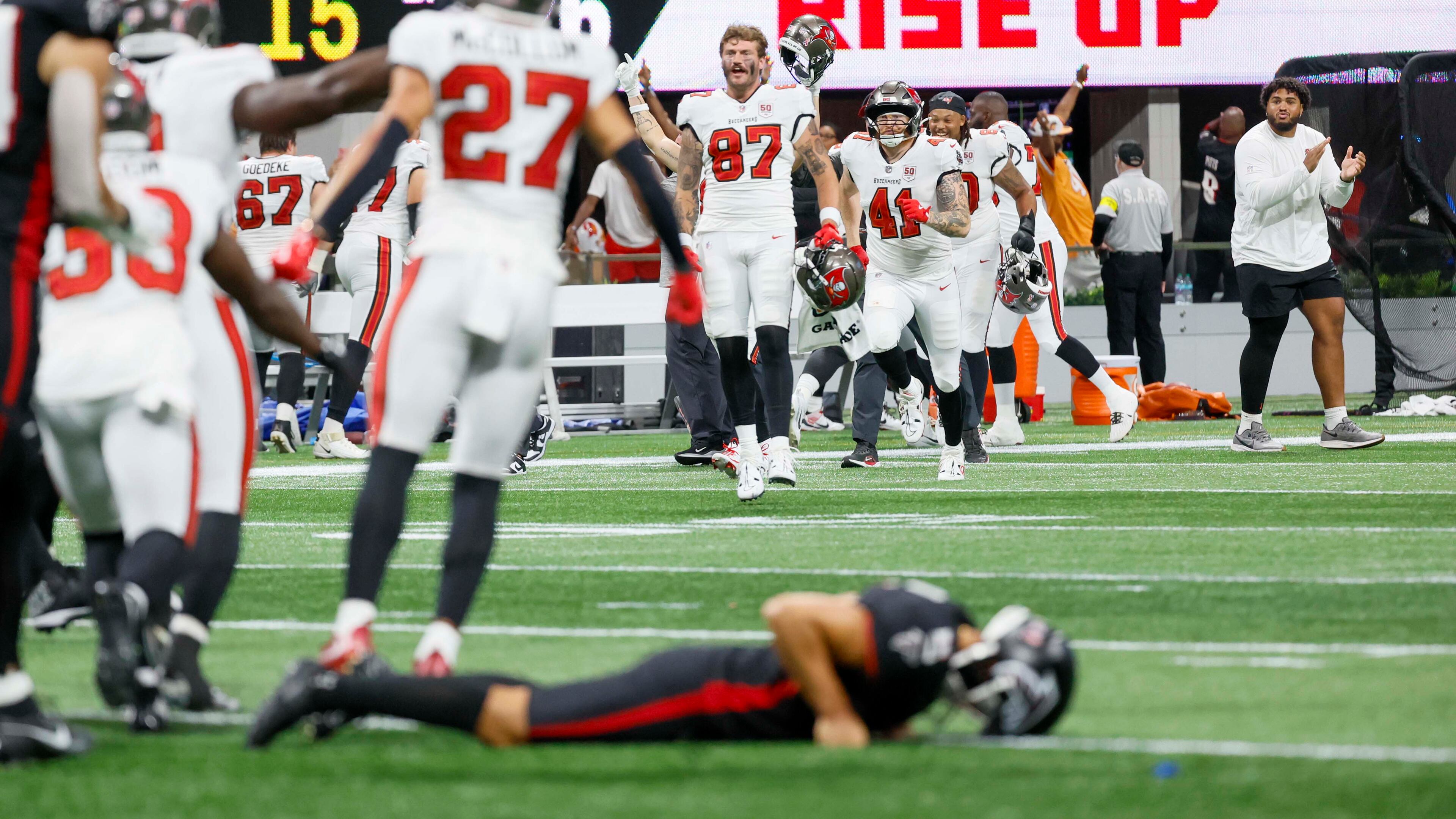Tampa Bay Buccaneers players celebrate as Atlanta Falcons placekicker Younghoe Koo lies on the ground after missing a last-second field goal. The Atlanta Falcons lost their home opener 23-20 to the Tampa Bay Buccaneers at Mercedes-Benz Stadium on Sunday, Sept. 7, 2025, in Atlanta. (Miguel Martinez/AJC)