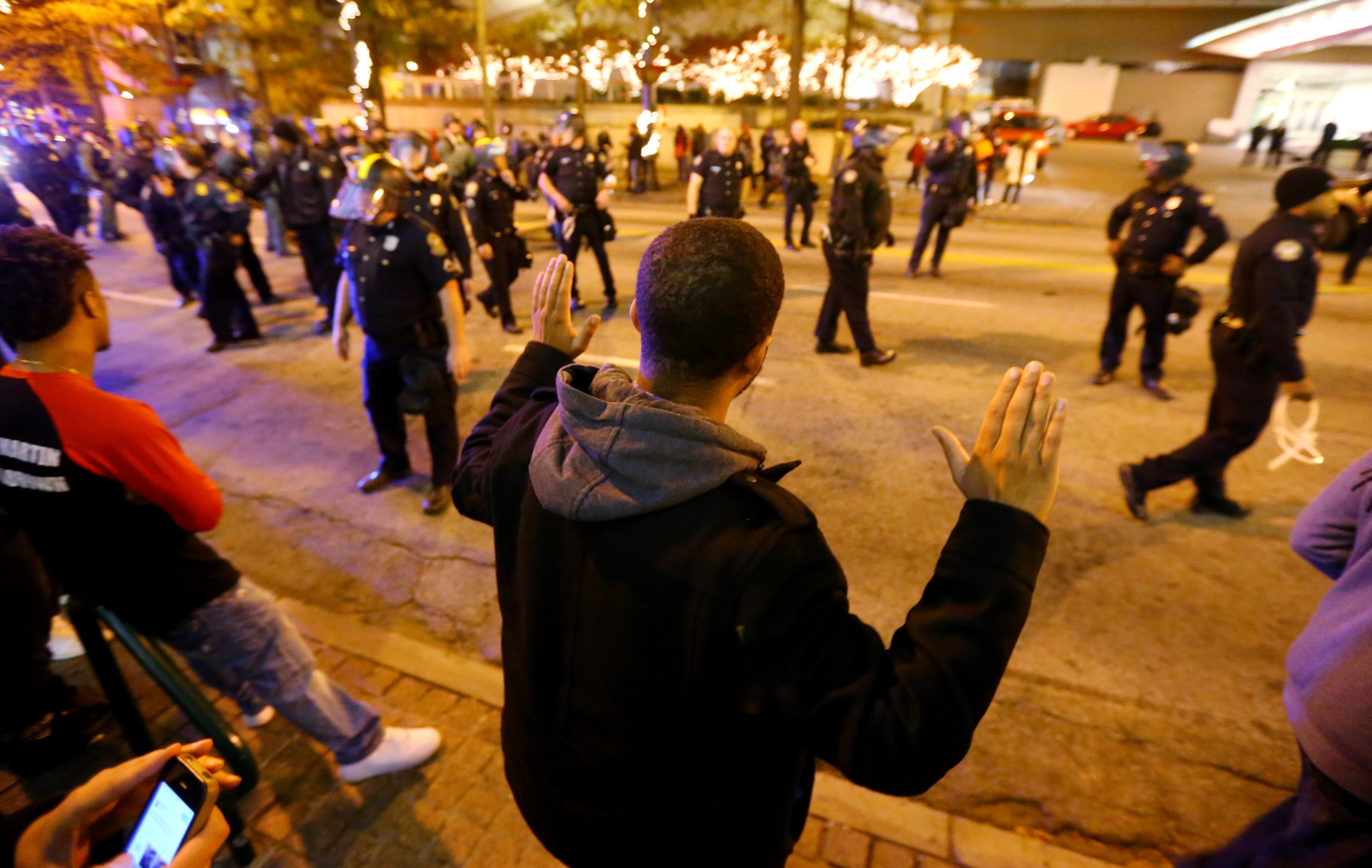 Protesters face off with Atlanta police after they forced them out of the road to the side walk on Peachtree Street in Atlanta in the wake of the grand jury decision not to indict officer Darren Wilson in the shooting death of Ferguson, MO., teen Michael Brown. CURTIS COMPTON / CCOMPTON@AJC.COM