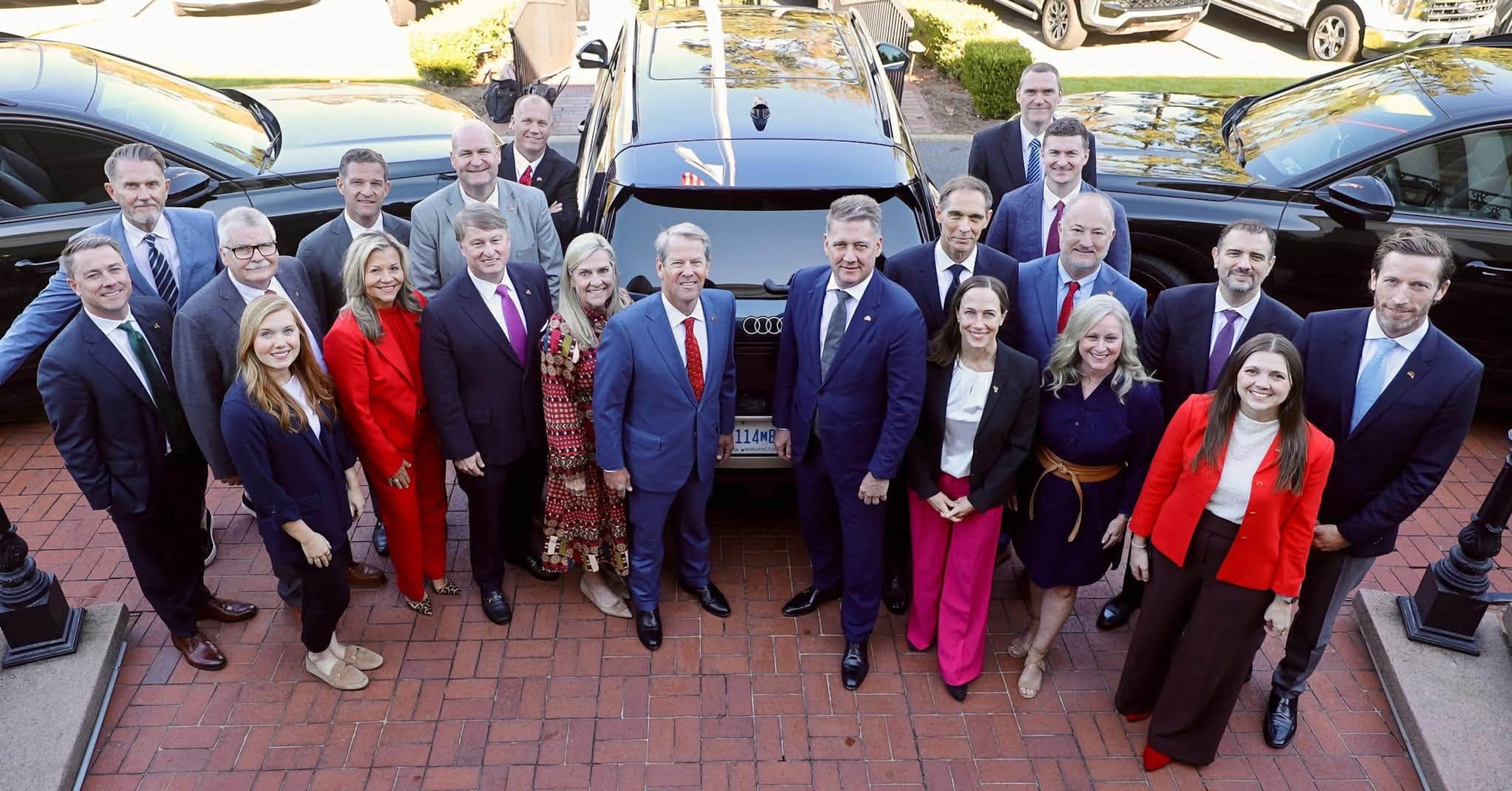 Georgia leaders, including Gov. Brian Kemp, posed for a photo in Macon-Bibb County with Audi vehicles ahead of the the automaker's announced Fort Valley plant. Macon Mayor Lester Miller is among the local officials in the photo. (Courtesy of Lester Miller)