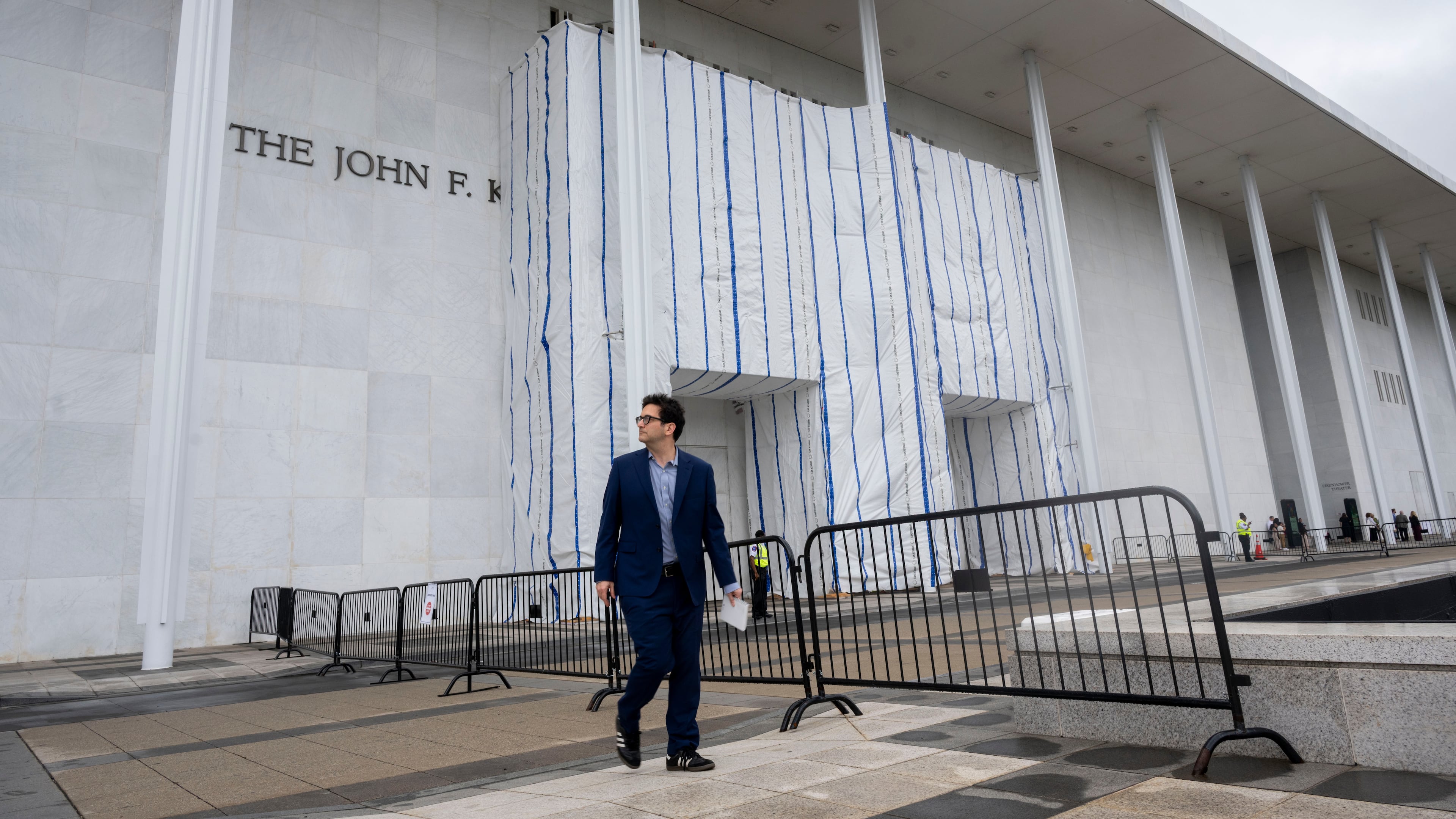 People walk near the tarp covered front entrance of the Kennedy Center for the Performing Arts before the start of the 27th Annual Mark Twain Prize for American Humor Celebrating Bill Maher, Sunday, June 29, 2026, in Washington. (AP Photo/Kevin Wolf)