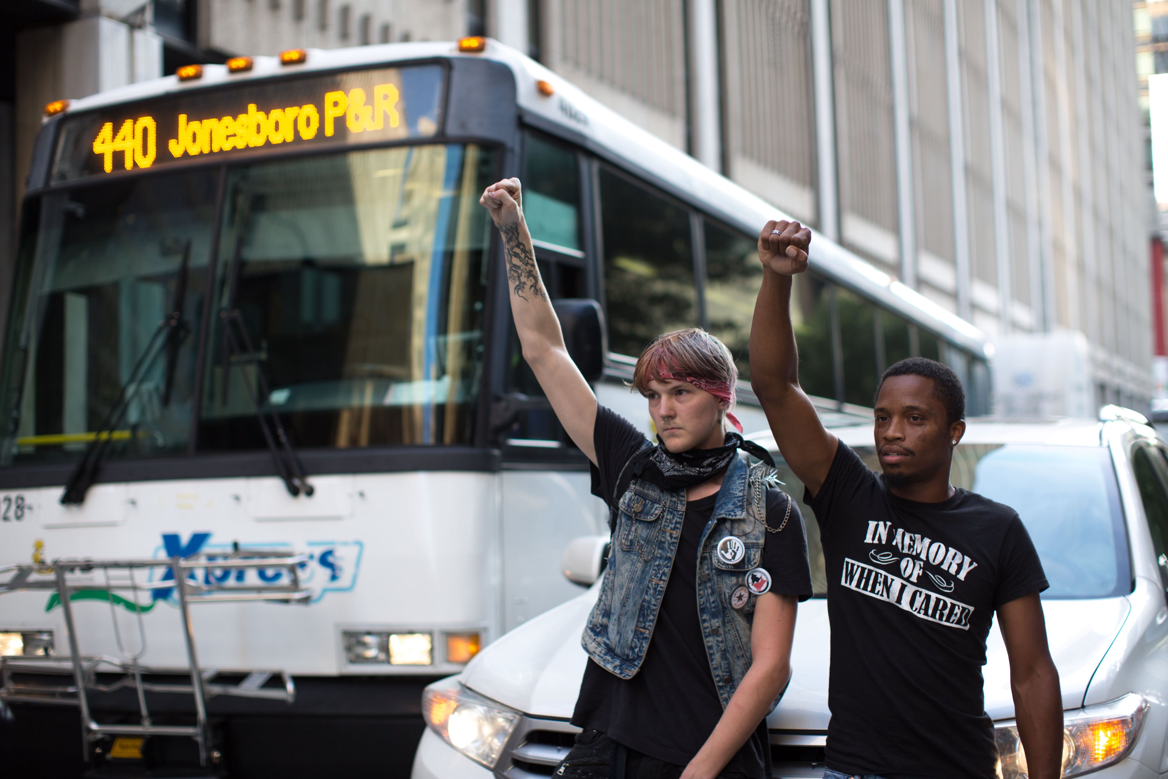 Two men block traffic as demonstrators protesting the most recent killings by police march down Peachtree Street to Piedmont Park, Thursday, July 7, 2016, in Atlanta. BRANDEN CAMP/SPECIAL