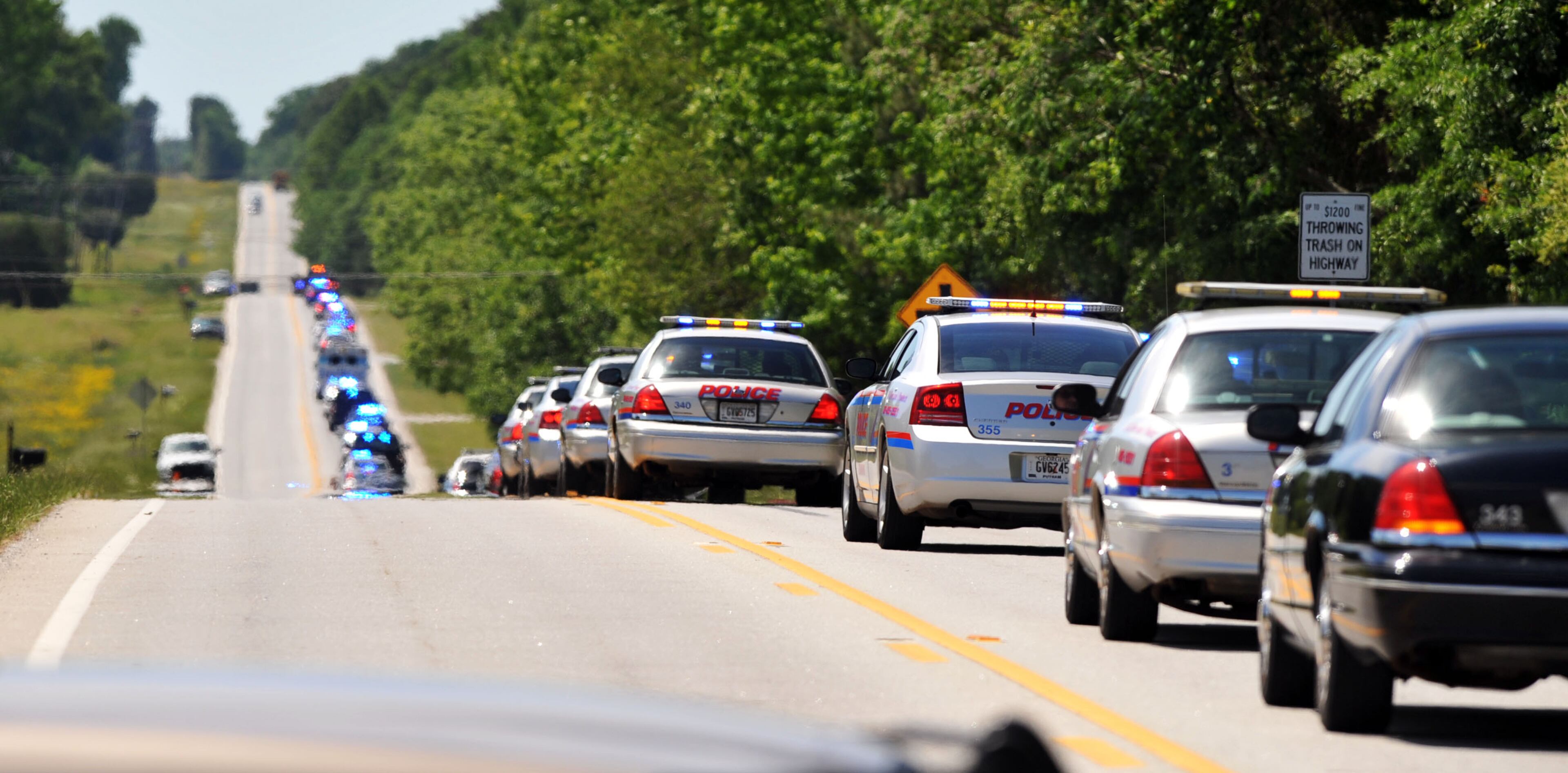 A mile-long procession of law enforcement, family and friends leaves the funeral chapel for the interment at the Rutledge cemetery. Officer Noel Lee Hawk was 52 when he suffered a fatal heart attack after breaking up a fight at an Eatonton fast-food restaurant.