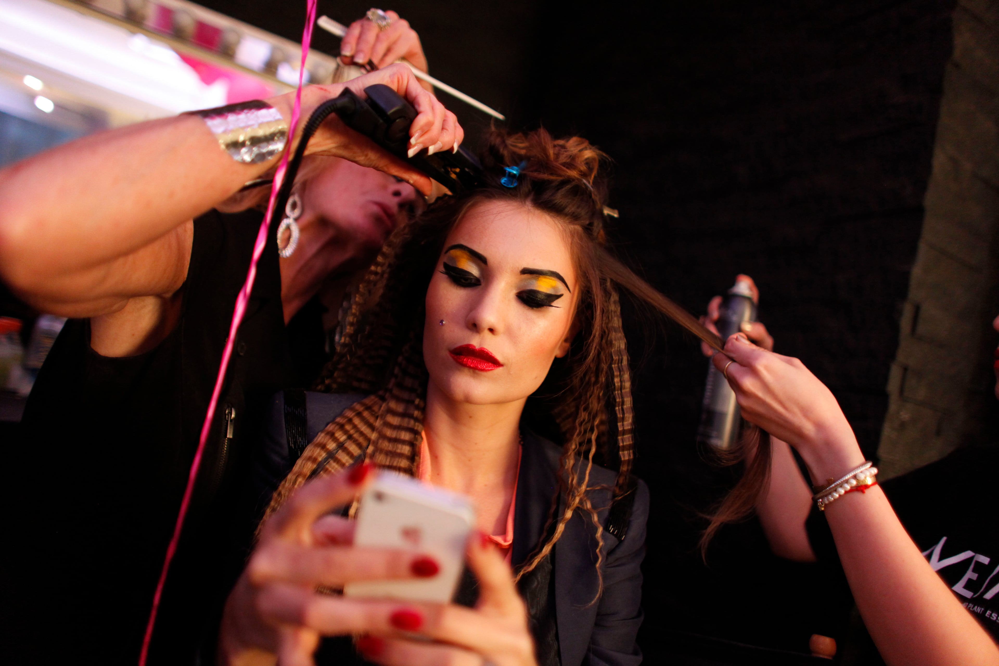 A model has her hair done backstage before the Betsey Johnson Spring 2013 collection show during Fashion Week, Tuesday, Sept. 11, 2012, in New York.