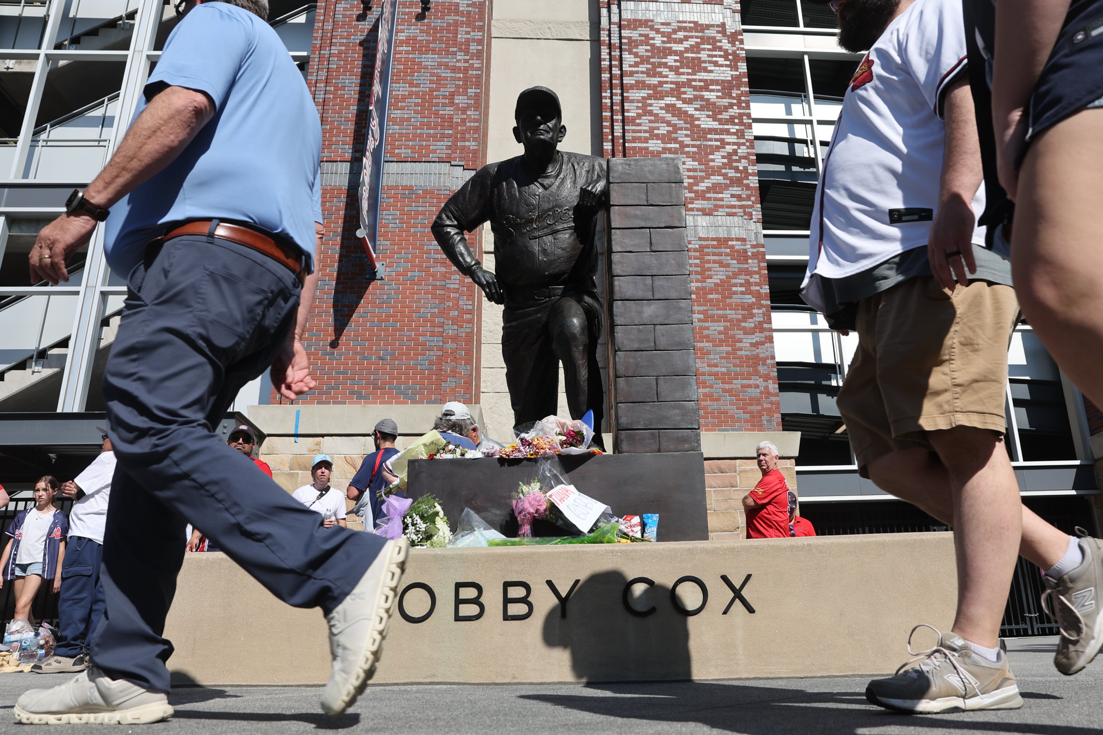 Fans left flowers and other items for the late legendary Braves manager Bobby Cox by his statue at Truist Park in Atlanta on May 12, 2026. Cox died at age 84 on Saturday May, 9. (Arvin Temkar/AJC)
