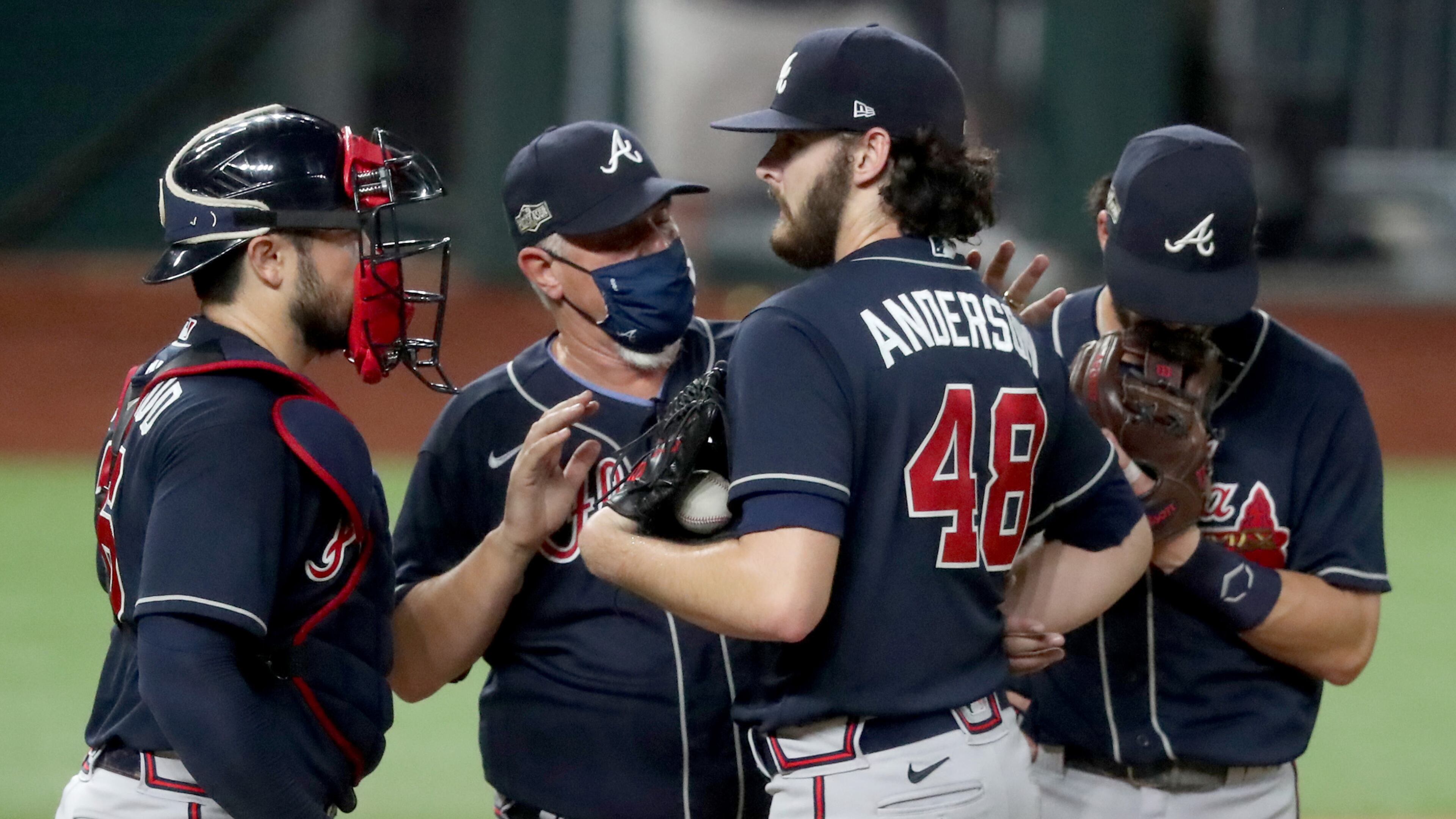 Braves pitching coach Rick Kranitz, center, talks with starting pitcher Ian Anderson (48), catcher Travis d'Arnaud, left, and shortstop Dansby Swanson, right, after Anderson allowed two runs agains the Los Angeles Dodgers during the third inning in Game 7 Sunday, Oct. 18, 2020, for the best-of-seven National League Championship Series at Globe Life Field in Arlington, Texas. (Curtis Compton/Atlanta Journal-Constitution/TNS)