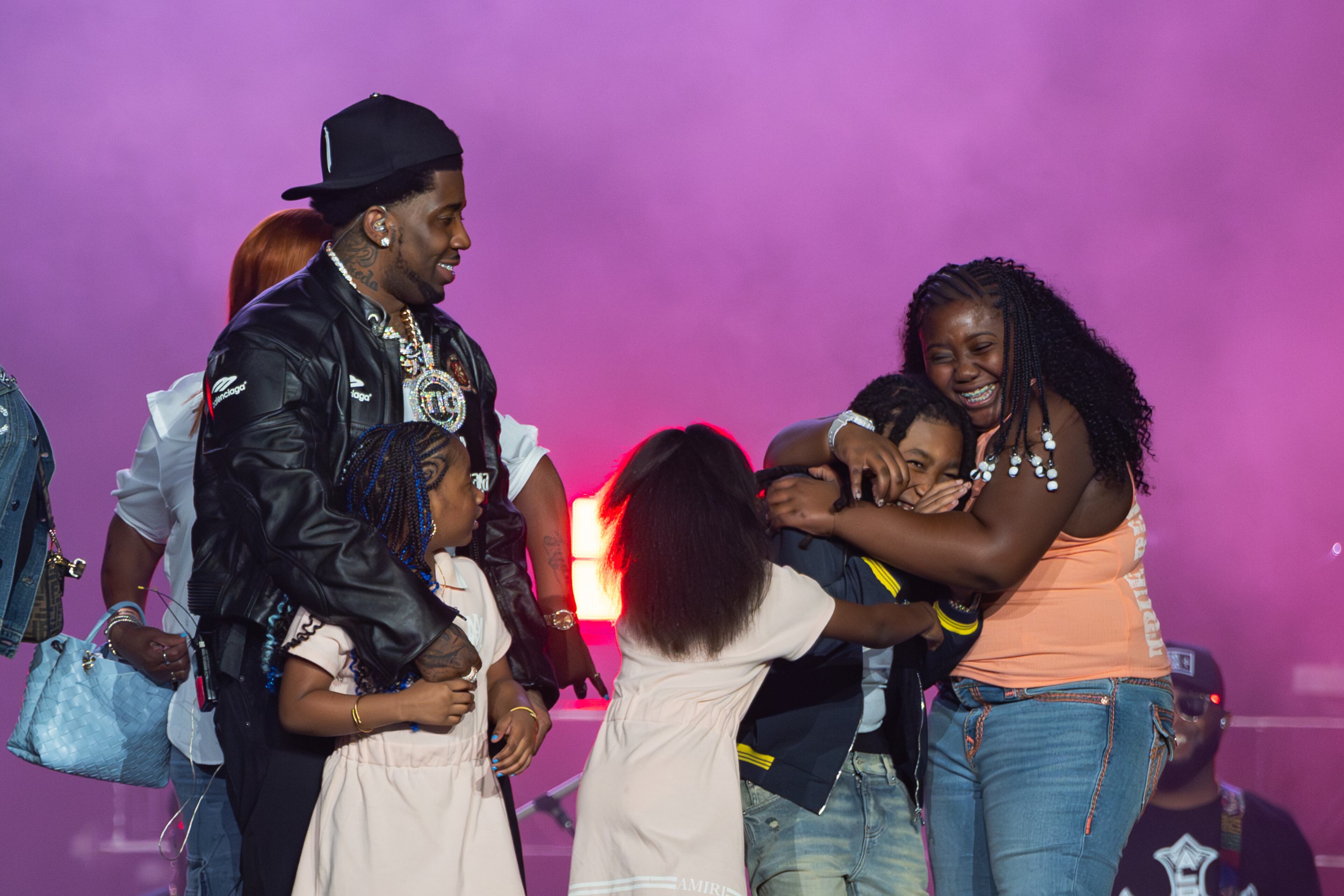 Rapper YFN Lucci's (left) four children join him on stage at the end of his sold-out homecoming show Saturday, Aug. 23, 2025, at State Farm Arena. (Courtesy of Scoot Holloway/State Farm Arena)