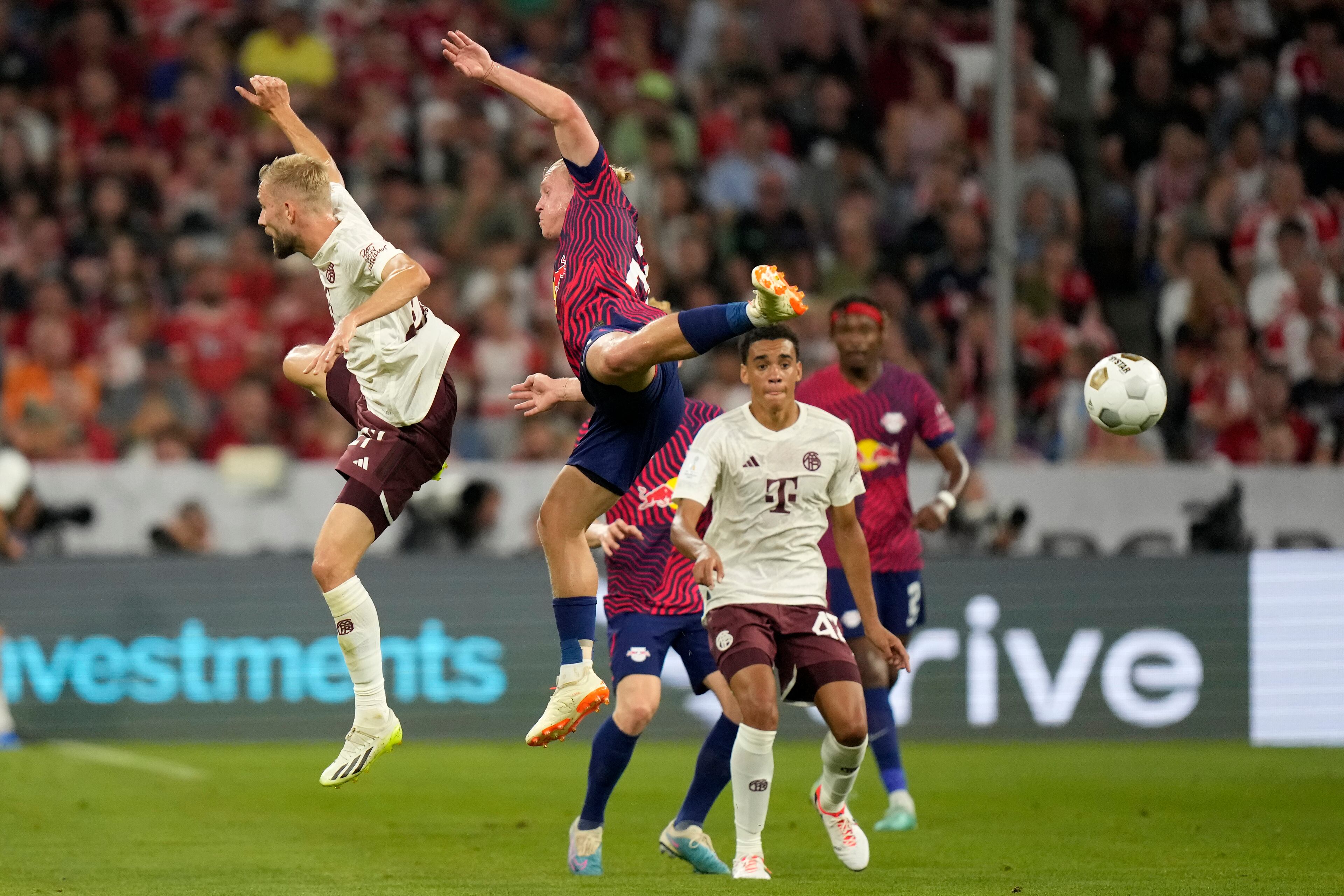 Leipzig's Xaver Schlager, right, challenges Bayern's Matthijs de Ligt during the German Super Cup final between FC Bayern Munich and RB Leipzig at the Allianz Arena stadium in Munich, Germany, Saturday, Aug. 12, 2023. (AP Photo/Matthias Schrader)
