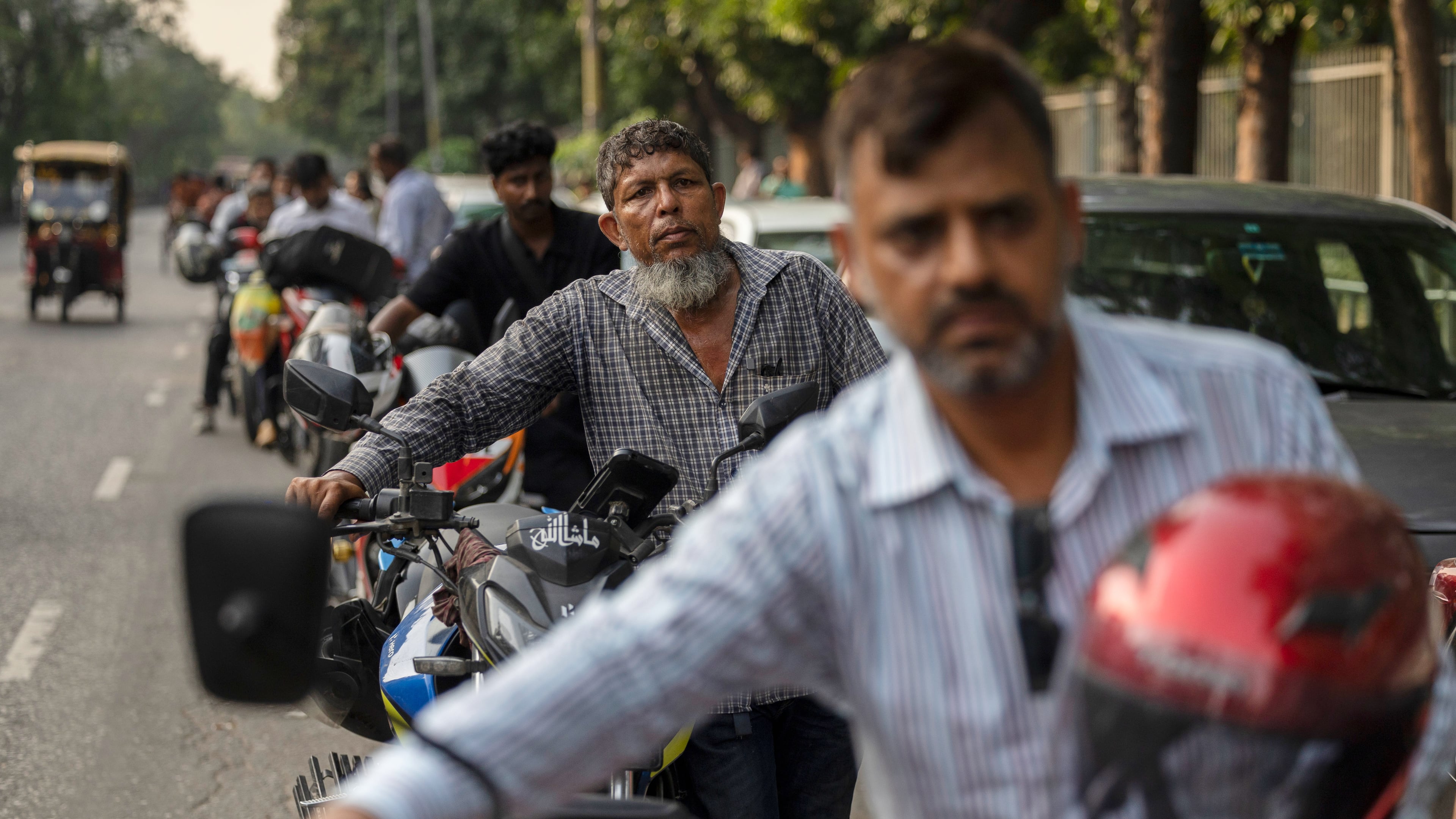 Tariqul Islam, a ride-share driver, waits in a long queue of petrol for his motorcycle in Dhaka, Bangladesh, Tuesday, April 23, 2026. (AP Photo/Abdul Goni)