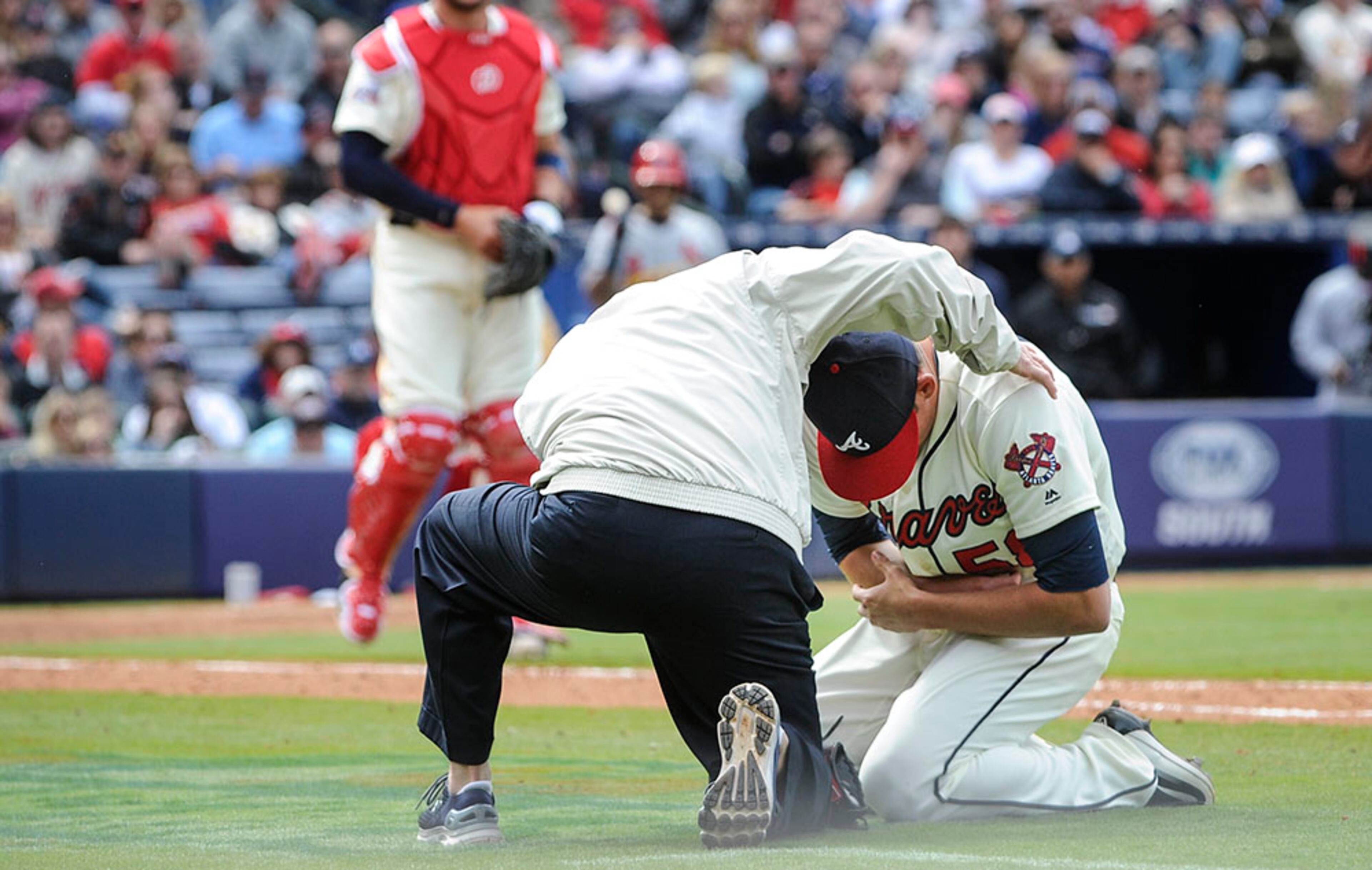 Atlanta Braves pitcher Dan Winkler (58) is tended to by Braves training personnel as catcher Tyler Flowers looks on during the middle of the seventh inning of a baseball game against the St. Louis Cardinals on Sunday, April 10, 2016, in Atlanta. Winkler collapsed on the field while trying to make it to the dugout after throwing a pitch. | Winkler suffered elbow fracture