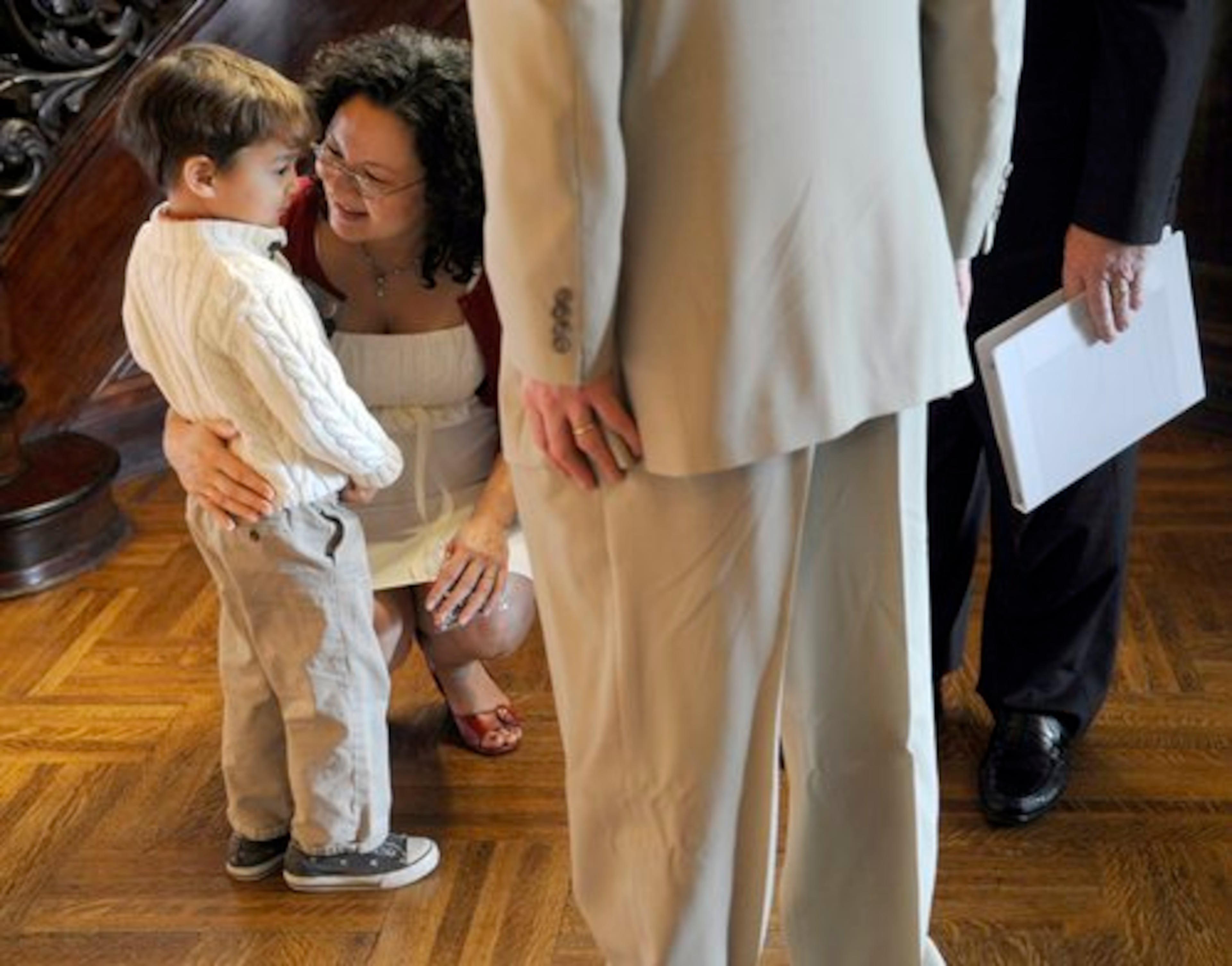 Jamie Ravenscraft kneels down to talk with her son, Zeke, 3, after renewing her vows with his father Aaron Cobb.