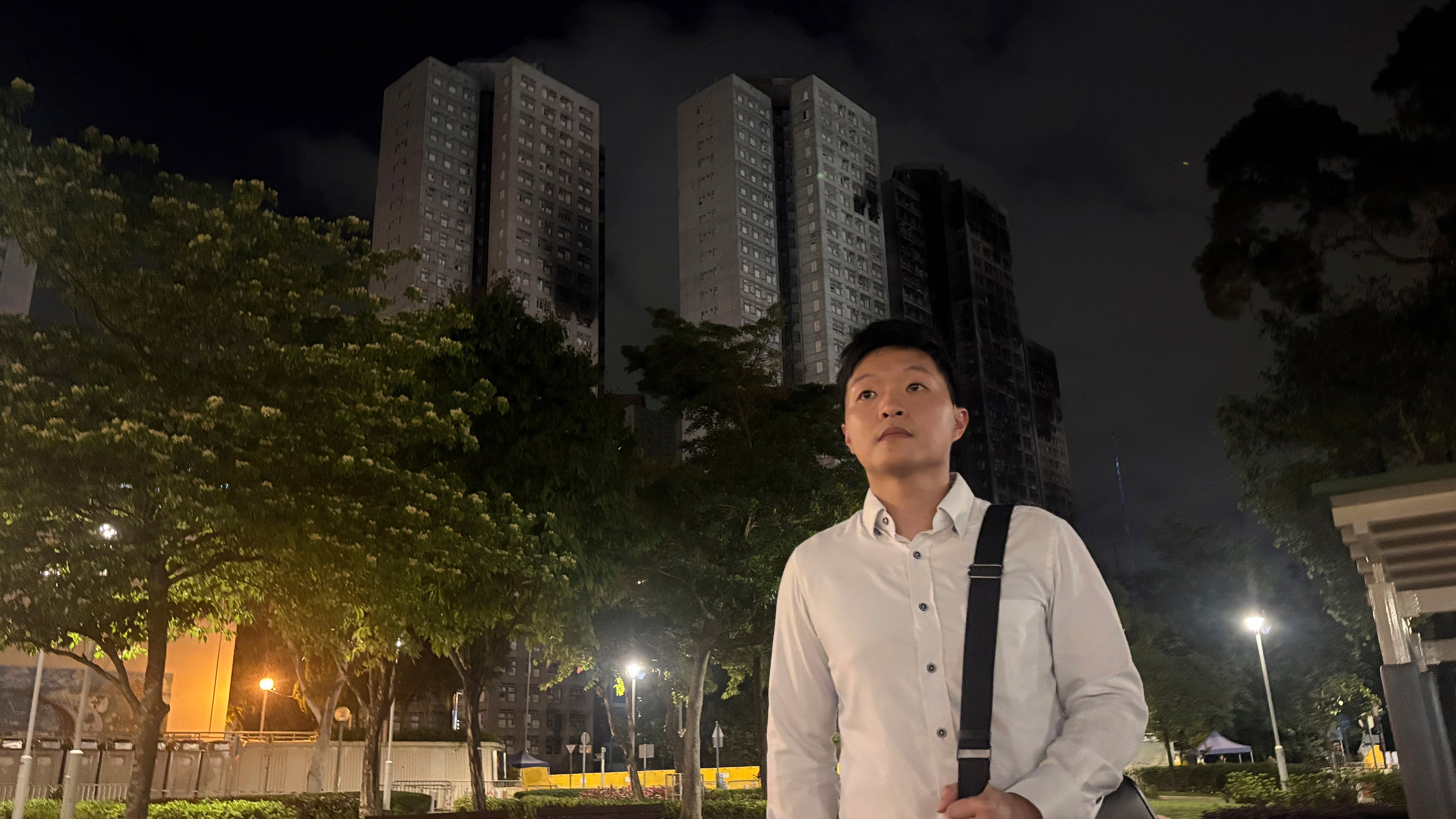 Resident Cyrus Ng poses for photos at a park near Wang Fuk Court, the apartment complex hit by Hong Kong's deadliest fire in decades, Monday, April 13, 2026. (AP Photo/Kanis Leung)
