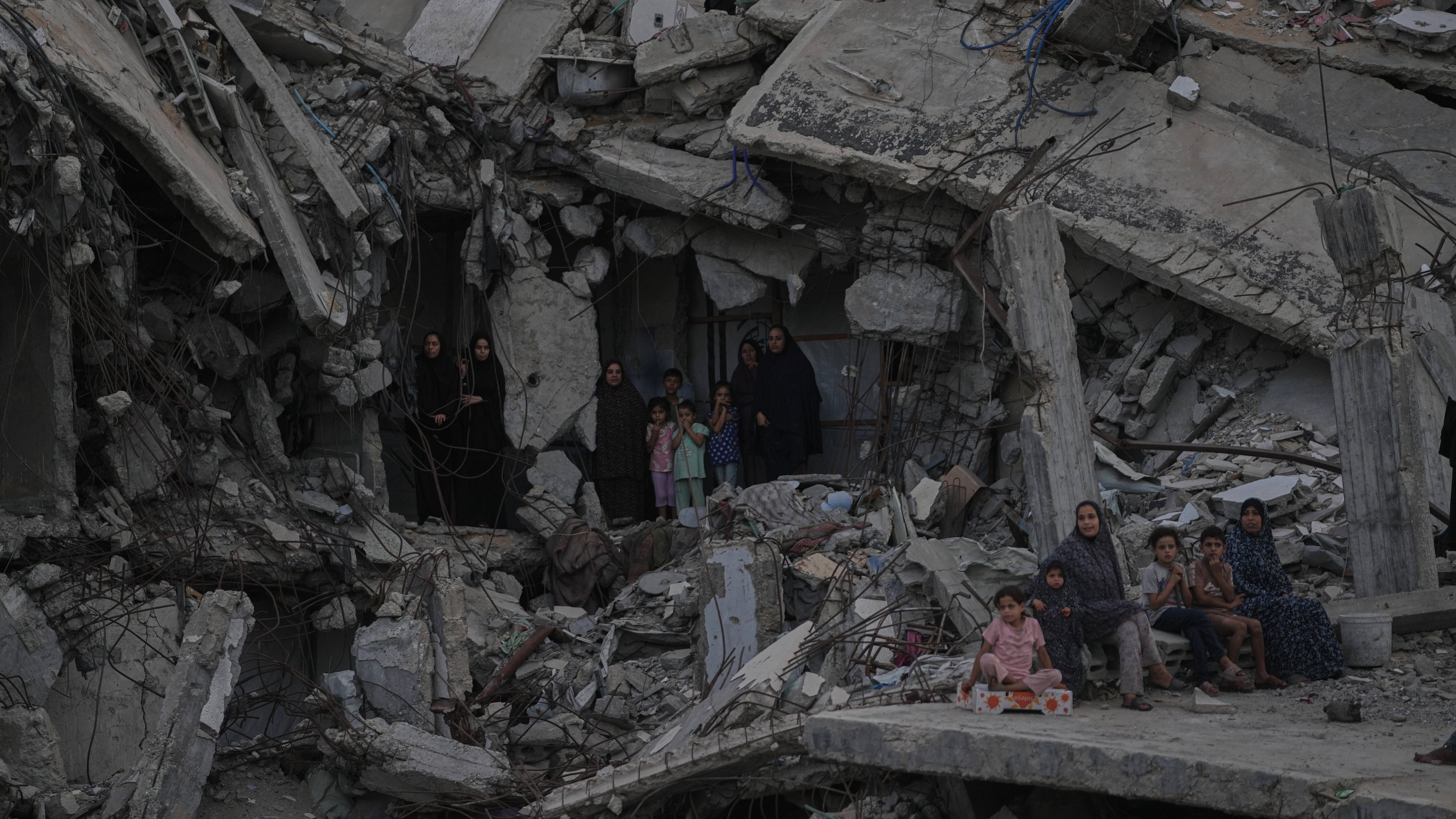 Palestinian women and children watch the Palestine Strongman Championship from among the rubble of destroyed buildings in Gaza City, Friday, Oct. 16, 2026. (AP Photo/Jehad Alshrafi)