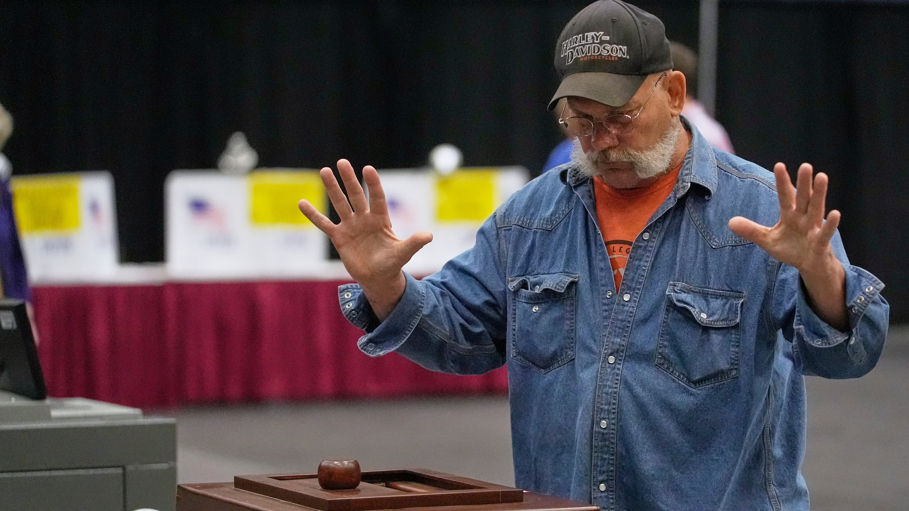 A Mainer reacts after his papers successfully dropped into to a ballot box while voting in the Maine Primary, Tuesday, June 9, 2026, in Augusta, Maine. (AP Photo/Robert F. Bukaty)