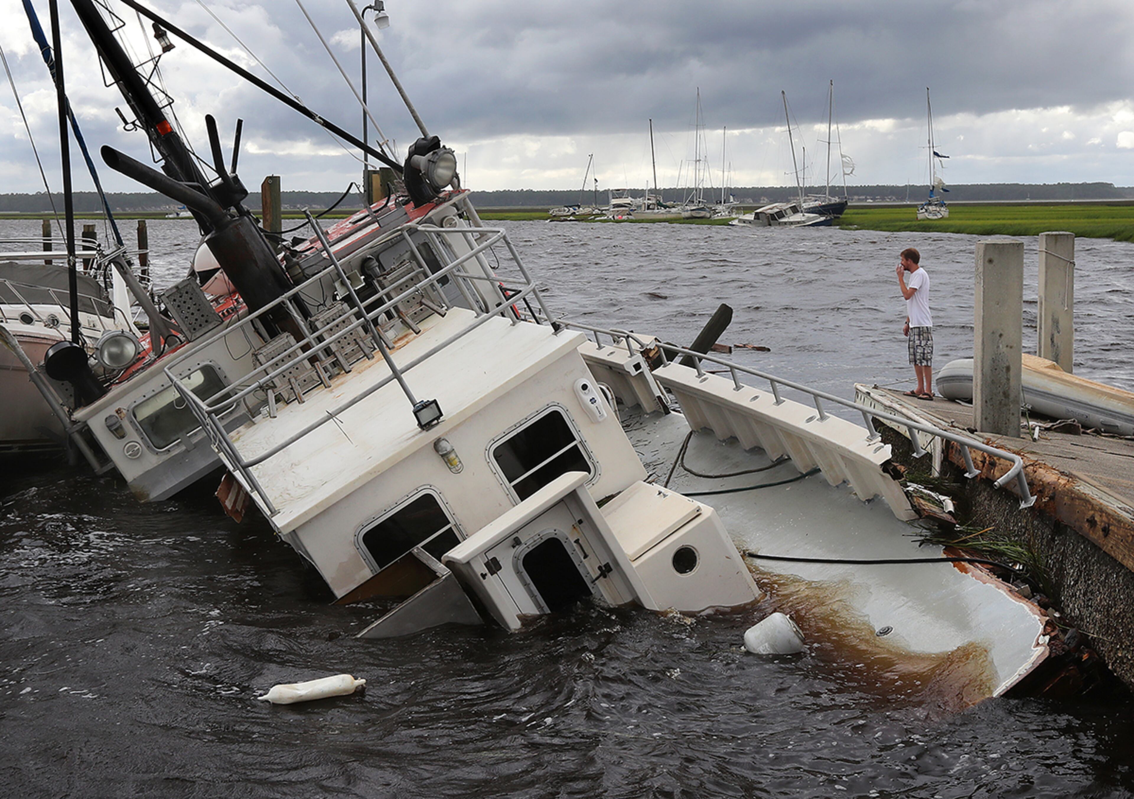September 11, 2017 St. Marys: Dozens of boats are blown into the marsh and a shrimp boat sits on the bottom as local resident Michael Whitemore, 36, checks to see if a friendââ¬â¢s boat survived at Langs Marina after Hurricane Irma hit the town on Monday, September 11, 2017, in St. Marys. Curtis Compton/ccompton@ajc.com