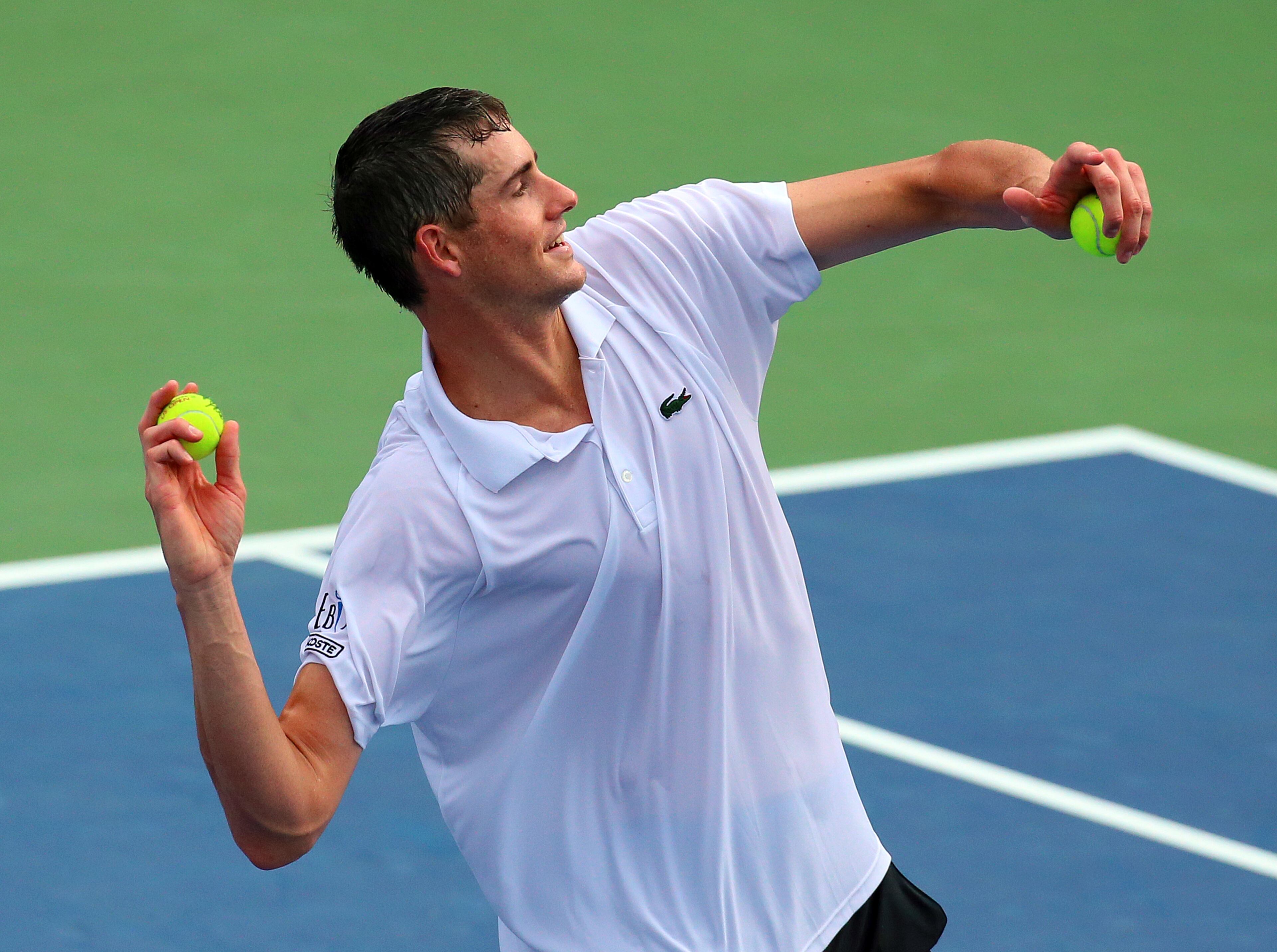 072813 ATLANTA: --John Isner throws tennis balls to his fans after defeating Kevin Anderson 6-7 (3), 7-6 (2), 7-6 (2) to win the BB&T Atlanta Open on Sunday, July 28, 2013, in Atlanta. CURTIS COMPTON / CCOMPTON@AJC.COM