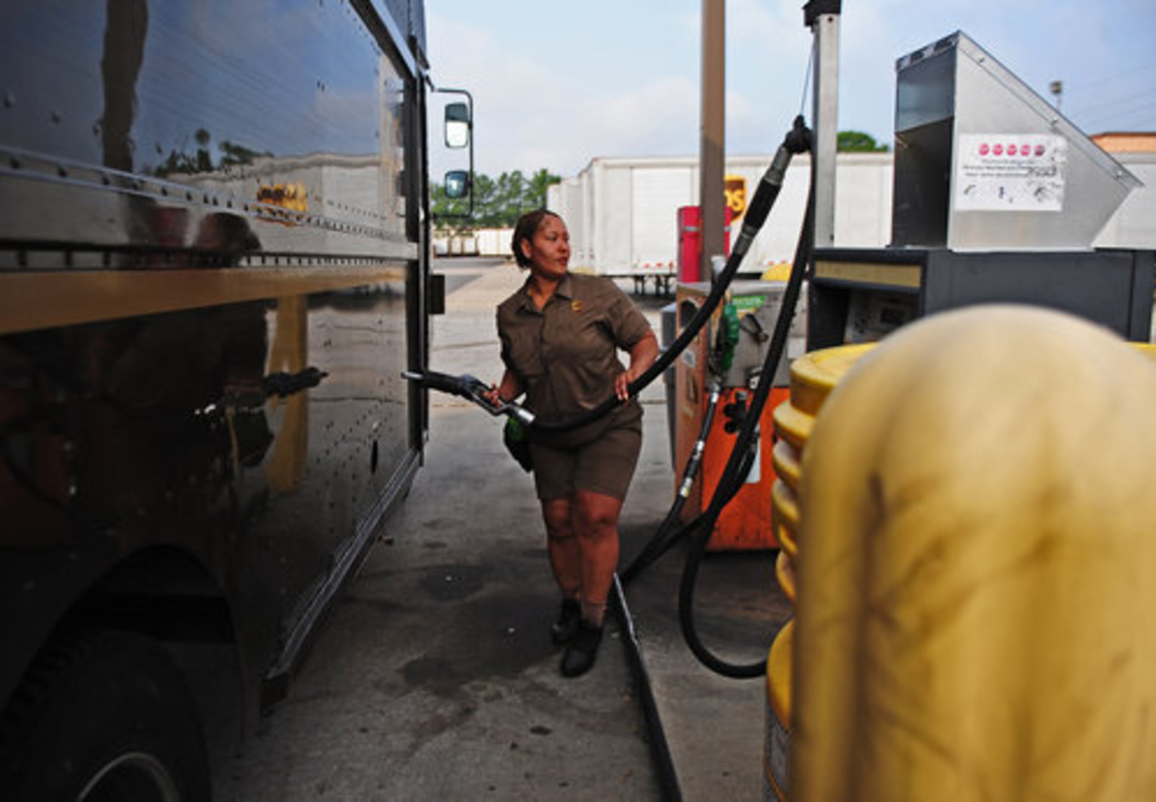 Driver Rachel Stone fuels up her truck with regular unleaded gasoline. UPS spokesman Norman Black said that the fuel surcharge doesn't cover UPS' entire cost of fuel.