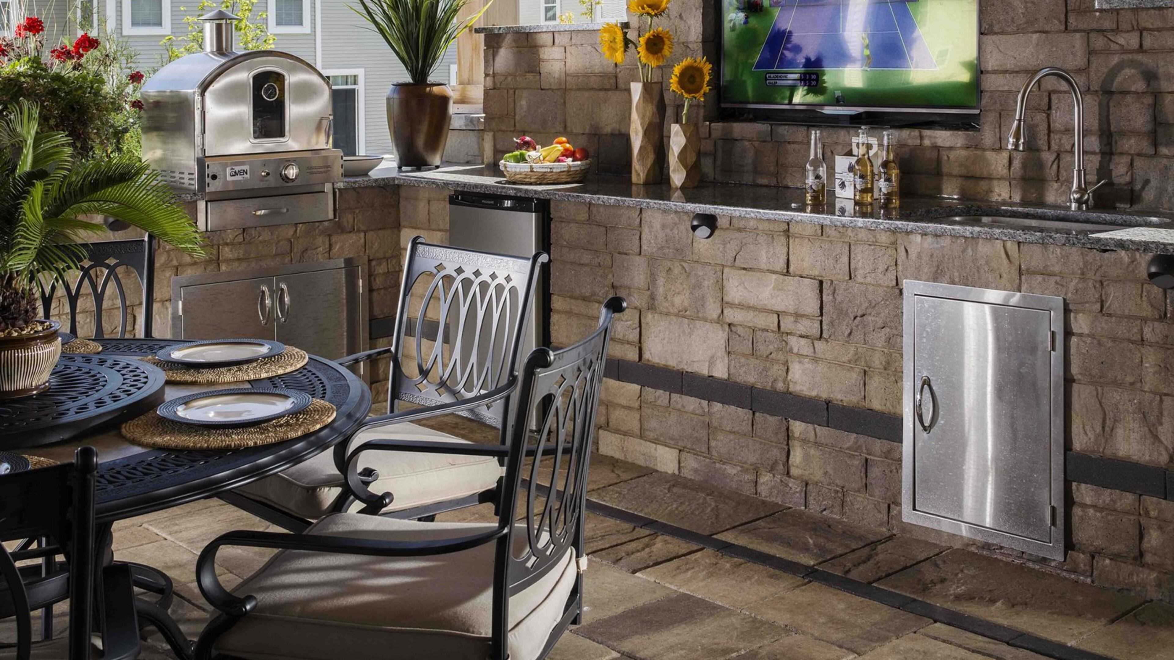 A high-tech outdoor kitchen and TV transform a basic outdoor patio. Contributed by Belgard