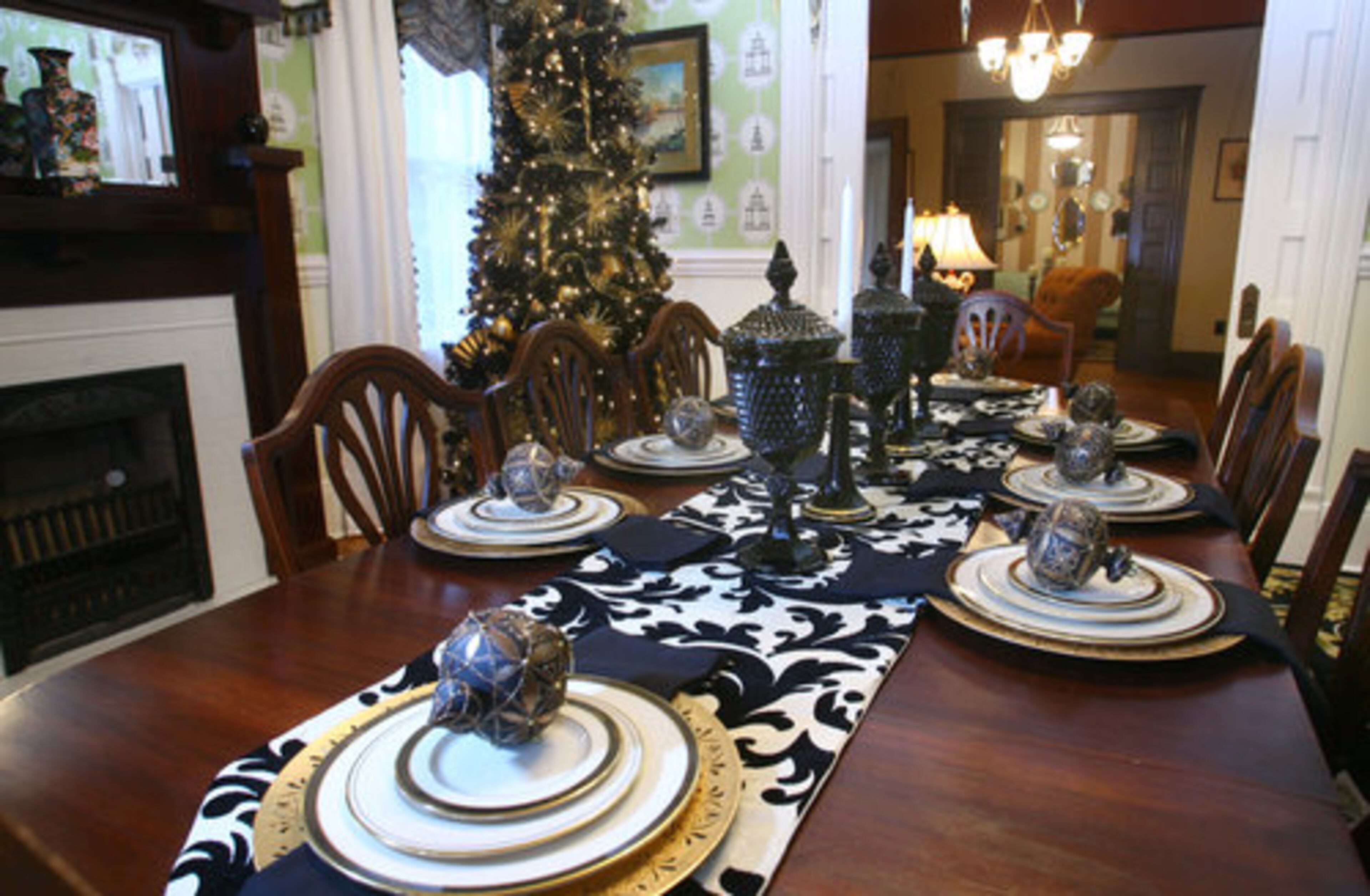 A black Christmas tree accented with gold anchors the holiday decor in the formal dining room. The house is filled with furniture both old and new, inherited antiques and purchased pieces.