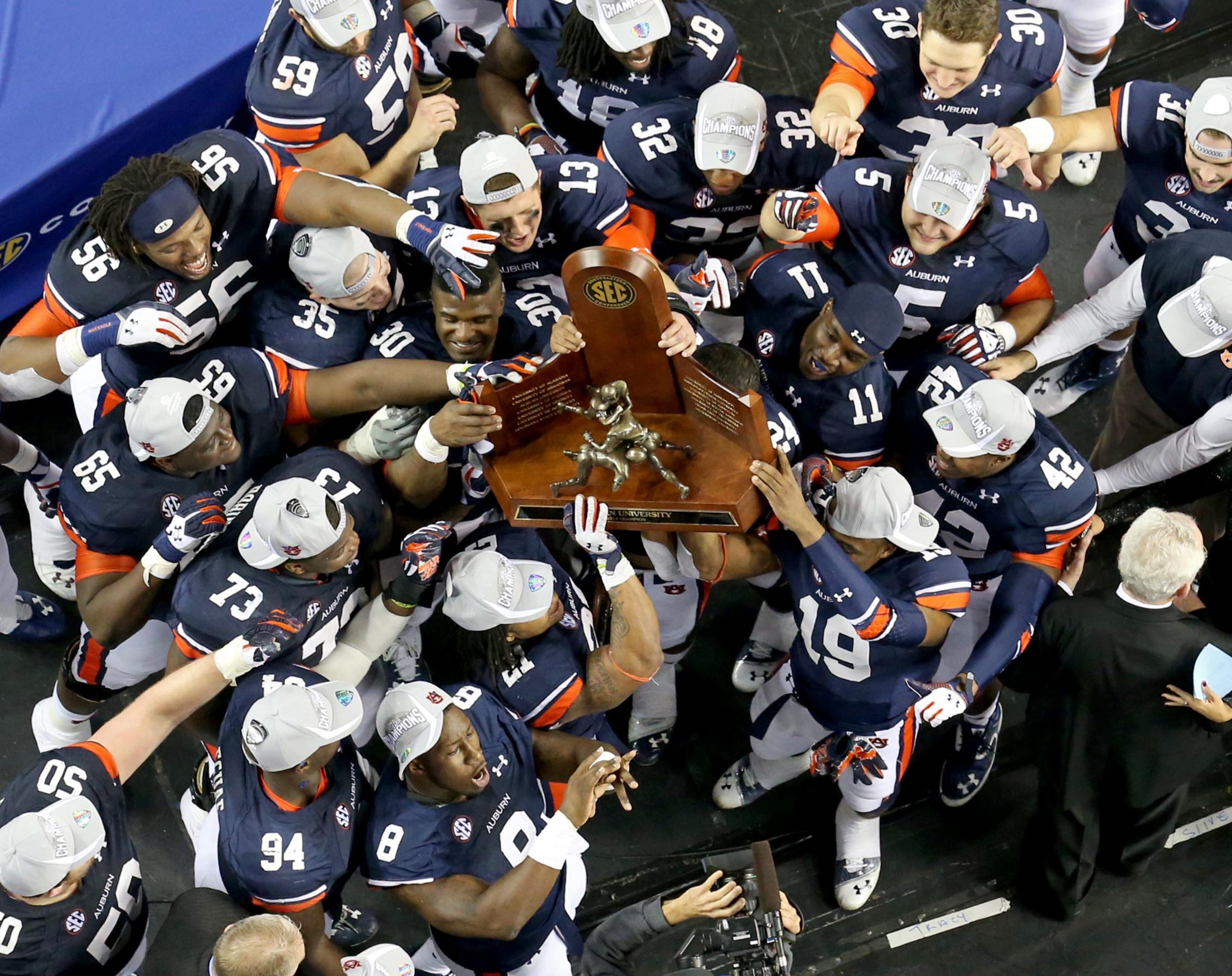 Auburn players hoist the SEC Championship trophy after defeating Missouri 59-42 in the SEC Championship Saturday night in Atlanta, Ga., December 7, 2013.