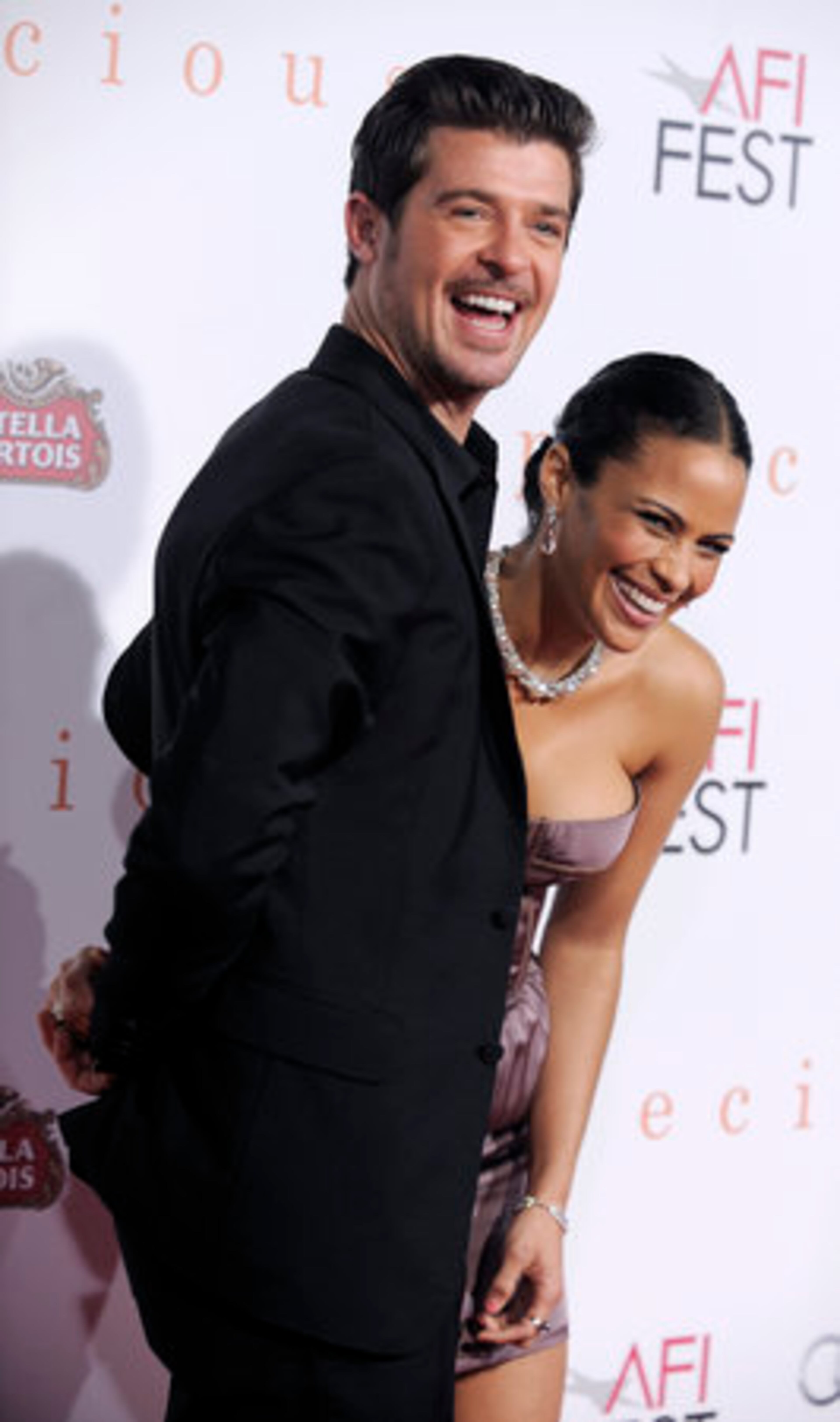 Paula Patton, right, a cast member in "Precious: Based on the Novel 'Push' by Sapphire, " and her husband Robin Thicke react to photographers.