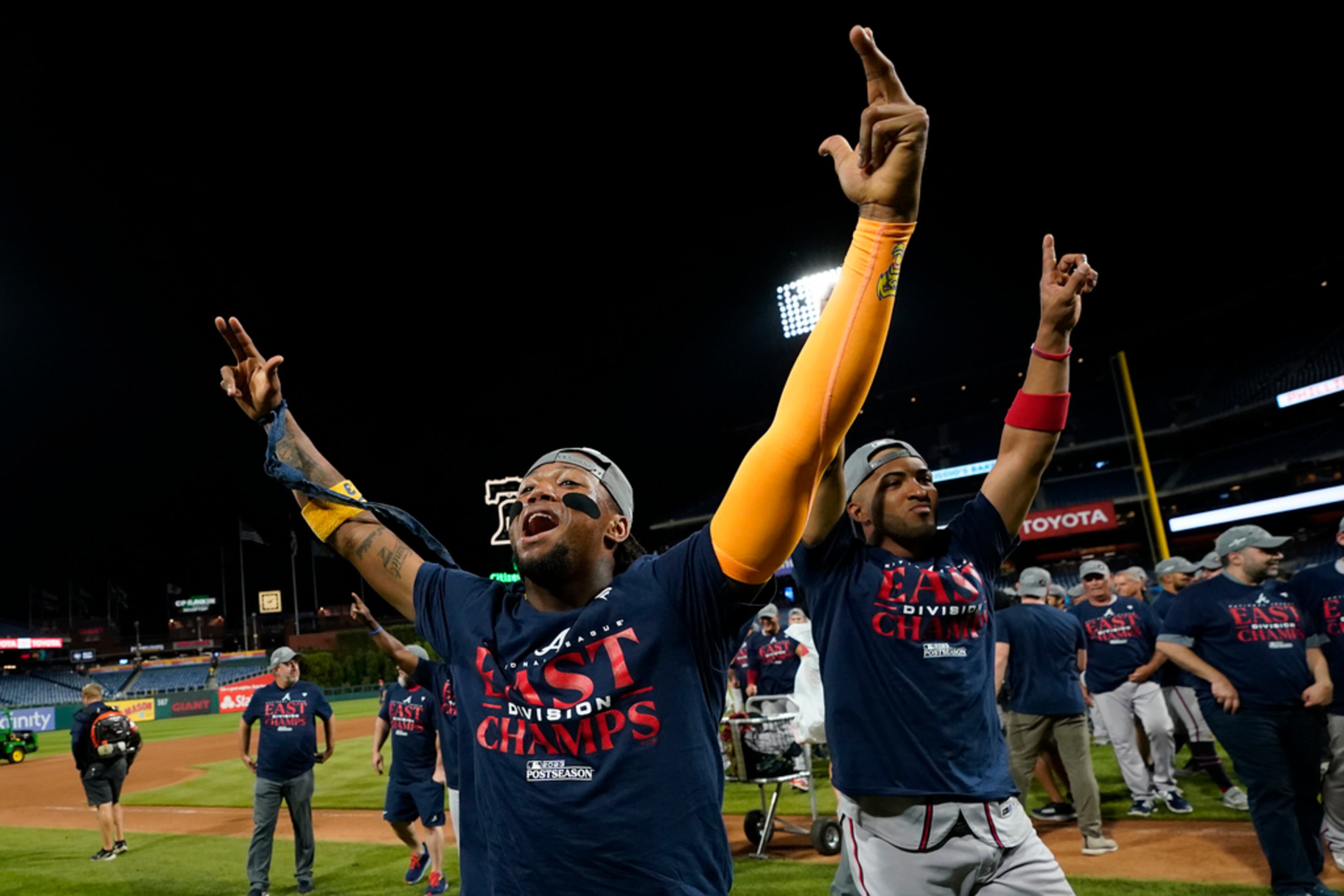 Atlanta Braves' Ronald Acuna Jr., left, and Eddie Rosario celebrate after clinching their sixth consecutive NL East title by defeating the Philadelphia Phillies in a baseball game, Wednesday, Sept. 13, 2023, in Philadelphia. (AP Photo/Matt Slocum)