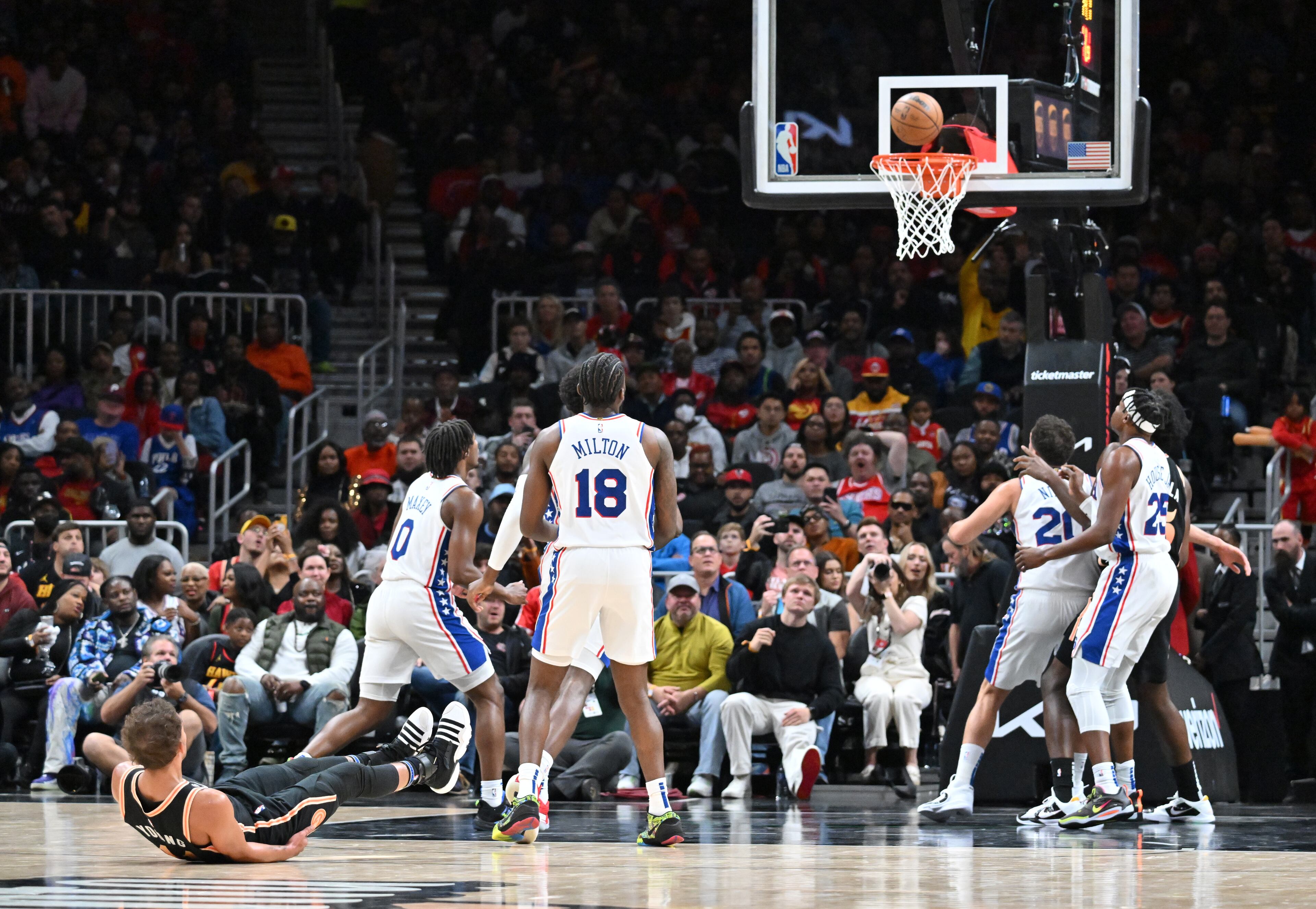 Hawks' guard Trae Young (left) falls to the floor as he scores during the second half. (Hyosub Shin / Hyosub.Shin@ajc.com)