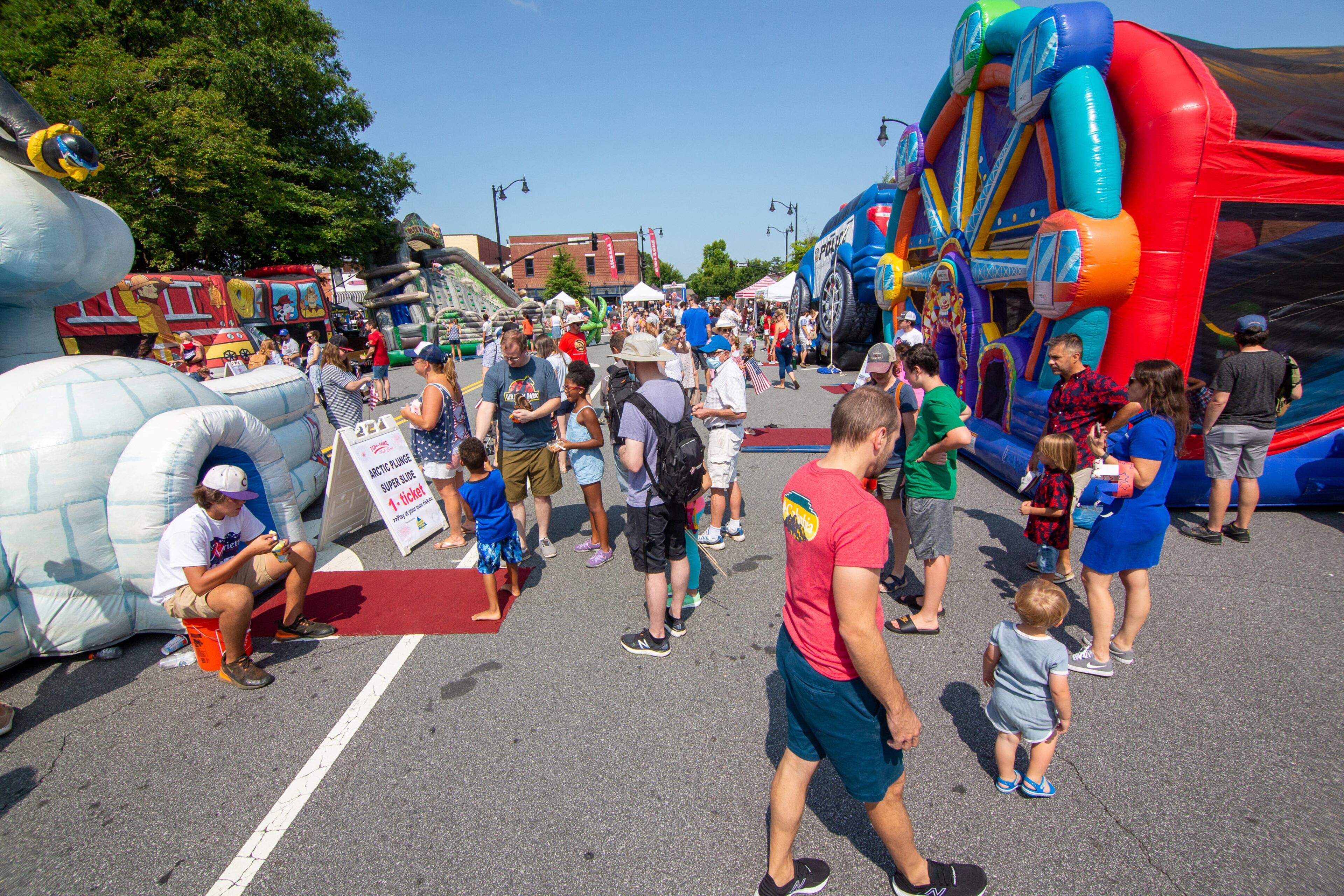 People walk around the kids' rides in Marietta Square during the city's Independence Day weekend celebrations on Saturday, July 3, 2021. (Photo: Steve Schaefer for The Atlanta Journal-Constitution)