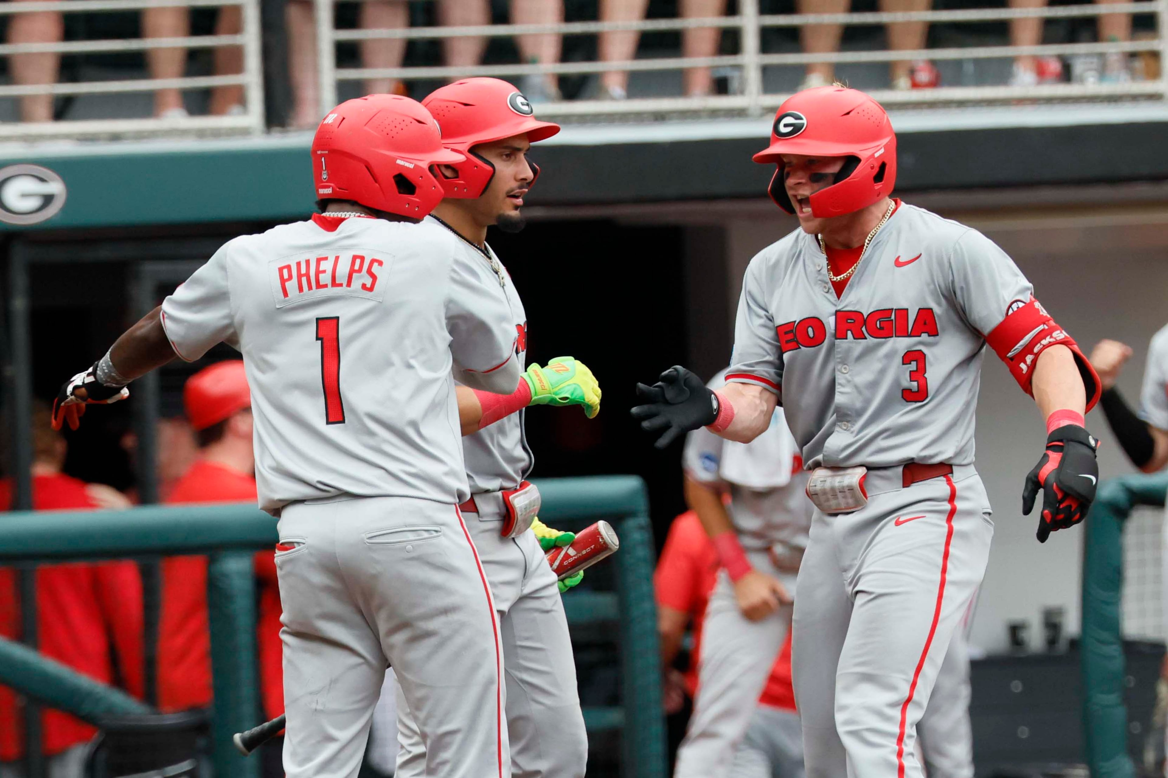 Georgia Bulldogs catcher Daniel Jackson (3) shakes hands with Georgia Bulldogs infielder Tre Phelps (1) at home plate after hitting a two-run home run to give the team an 11-9 lead in the tenth inning of game 2 of the NCAA Super Regional at Foley Field on Sunday, June 7, 2026, in Athens. Miguel Martinez/AJC)