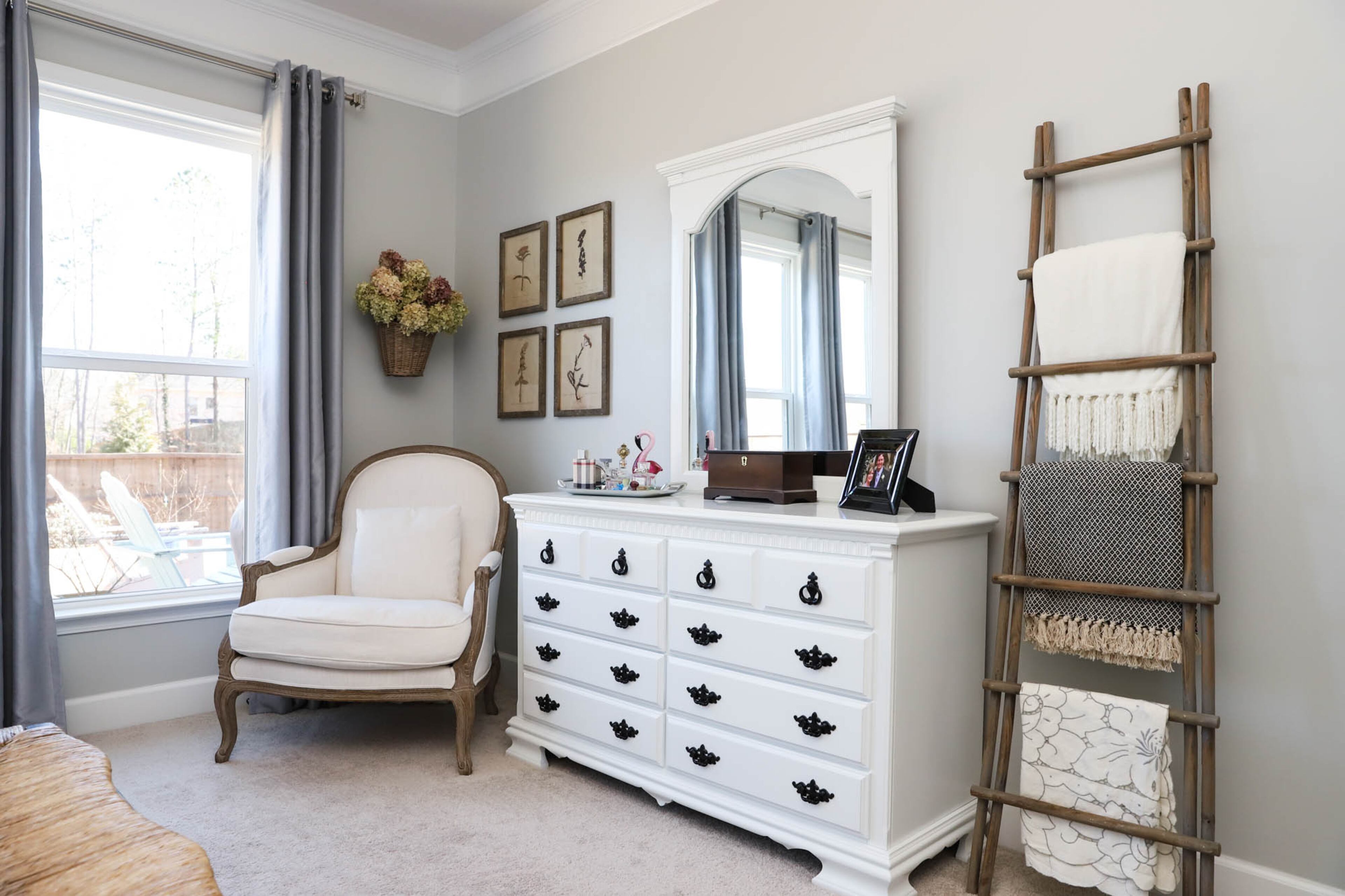 The bedroom suite furniture in Logan and Brenda Lineberry’s owner’s suite was originally purchased at The Furniture Shoppe, and it’s now painted in Sherwin-Williams Extra White. The Bergère Pottery Barn chair in the corner is from Facebook Marketplace, and both the blanket ladder and set of 4 botanical prints are from The Vintage Couple. For a final personal touch, Brenda picked and dried hydrangeas that now hang over the chair in the corner. Text by Shannon Dominy/Photo by Reynolds Rogers