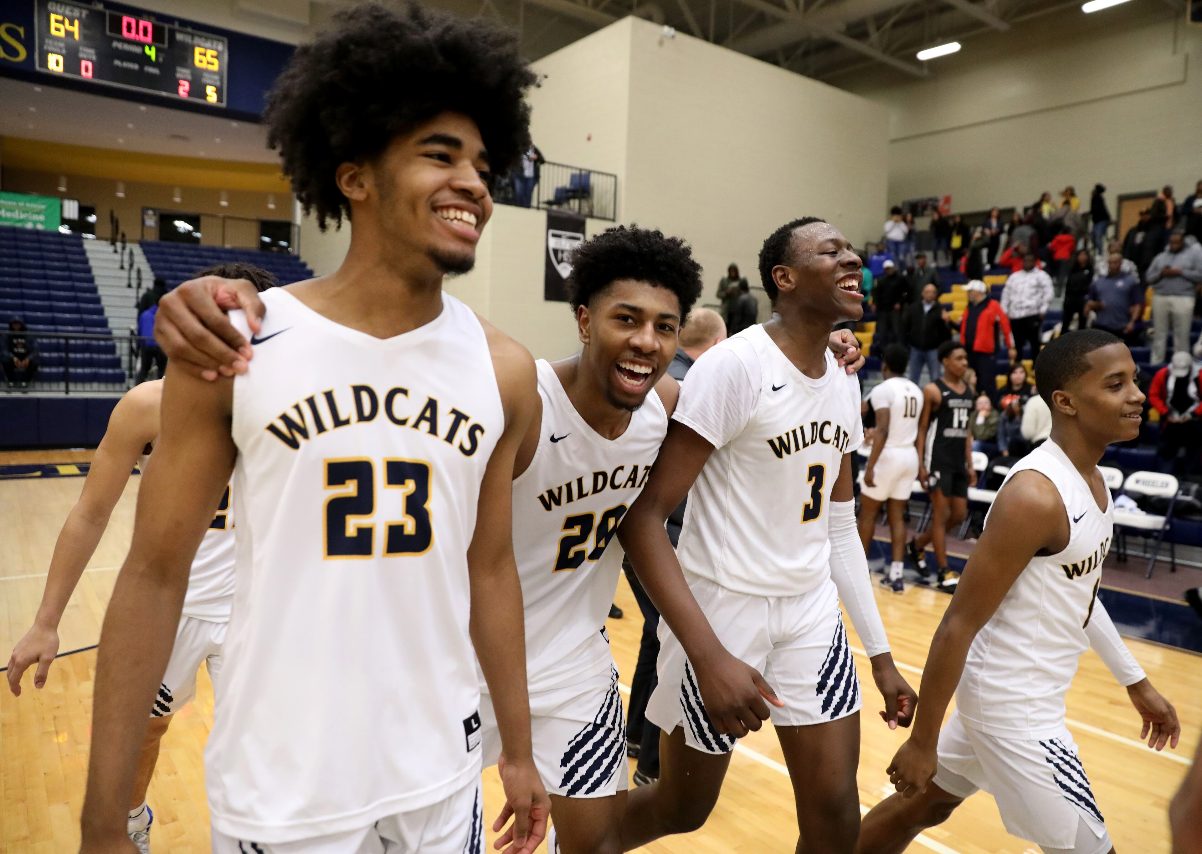 Wheeler forwards Jamill Giles (23), Samuel Hines Jr. (20) and Ja'Hiem Hudson (3) celebrate after the overtime win over Shiloh. (Jason Getz/Special to the AJC