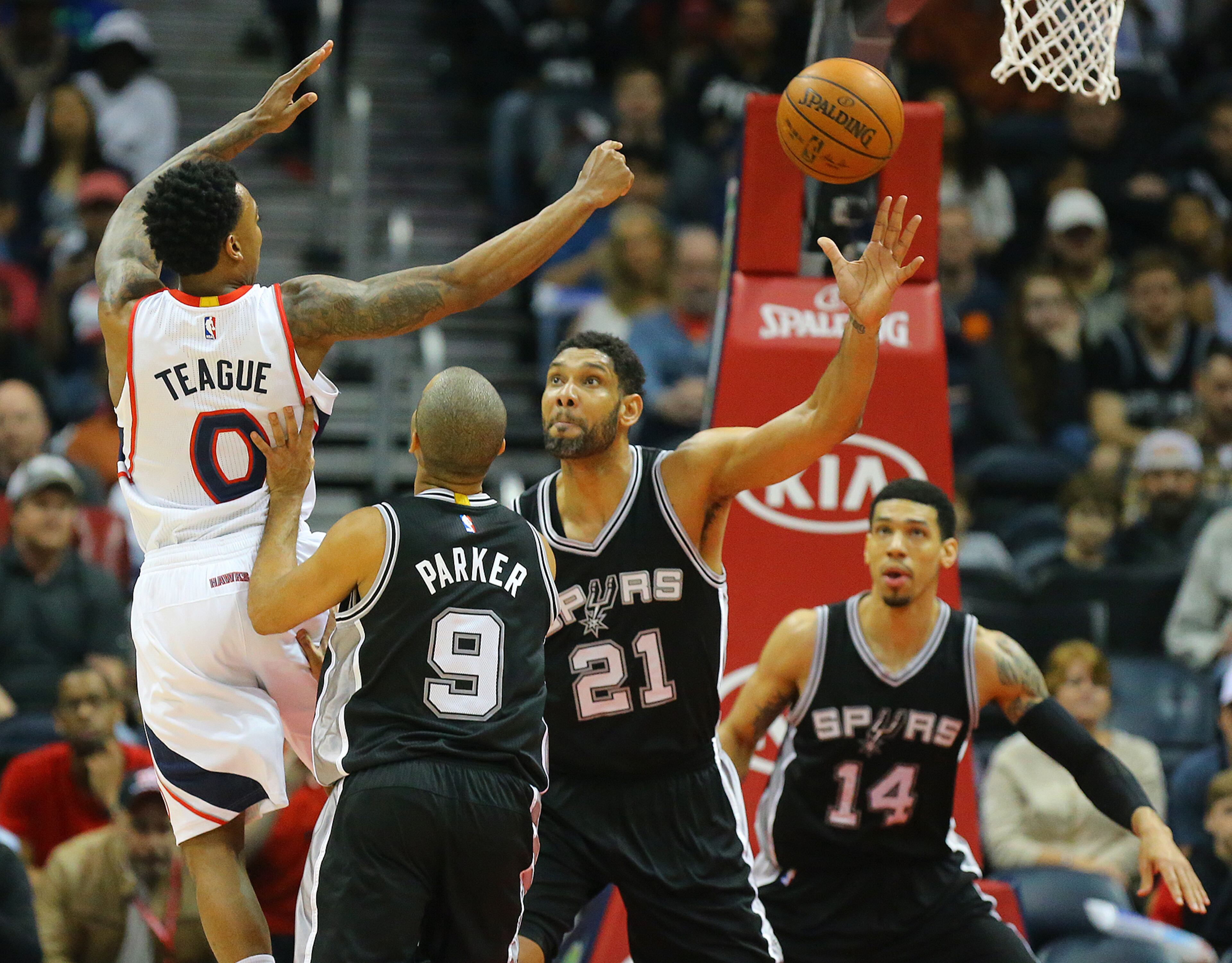 Hawks guard Jeff Teague is forced to pass off under pressure from Spurs defenders Tony Parker (from left), Tim Duncan and Danny Green during a basketball game on Sunday, March 22, 2015, in Atlanta. Curtis Compton / ccompton@ajc.com